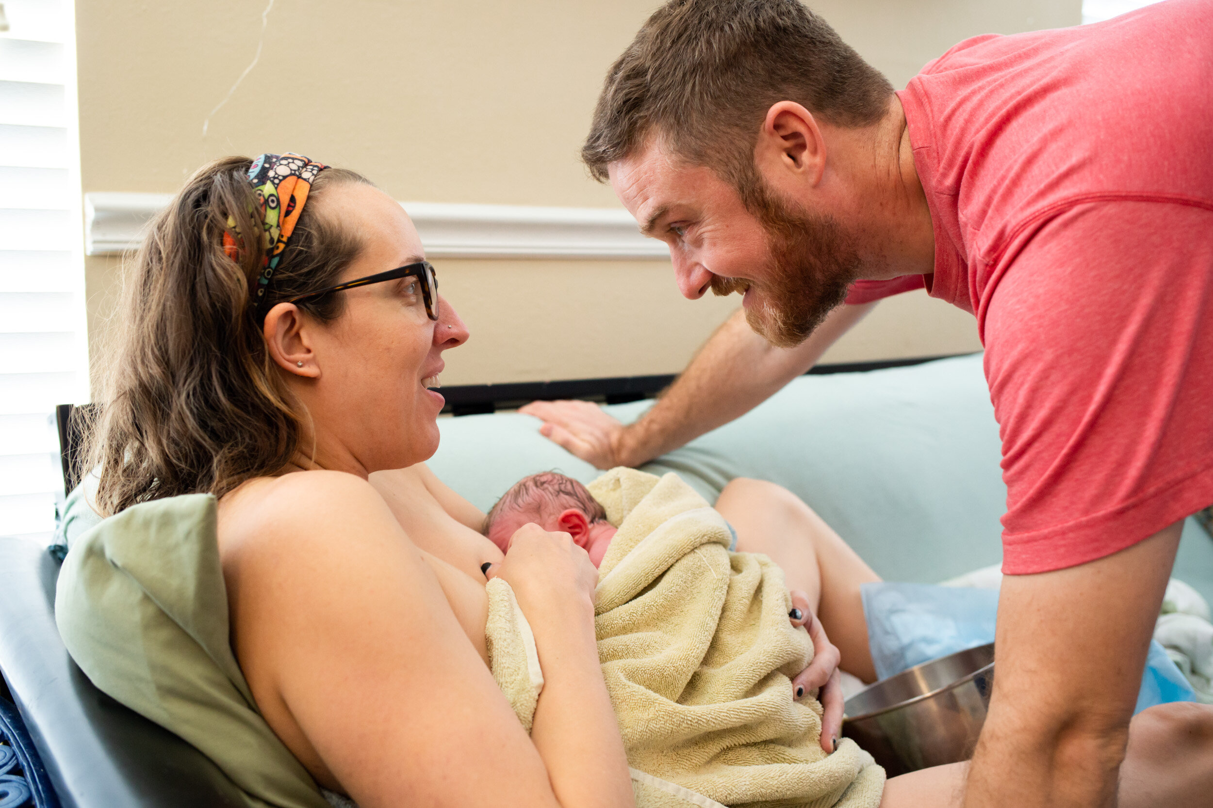 new parents smiling at each other after birth of baby boy