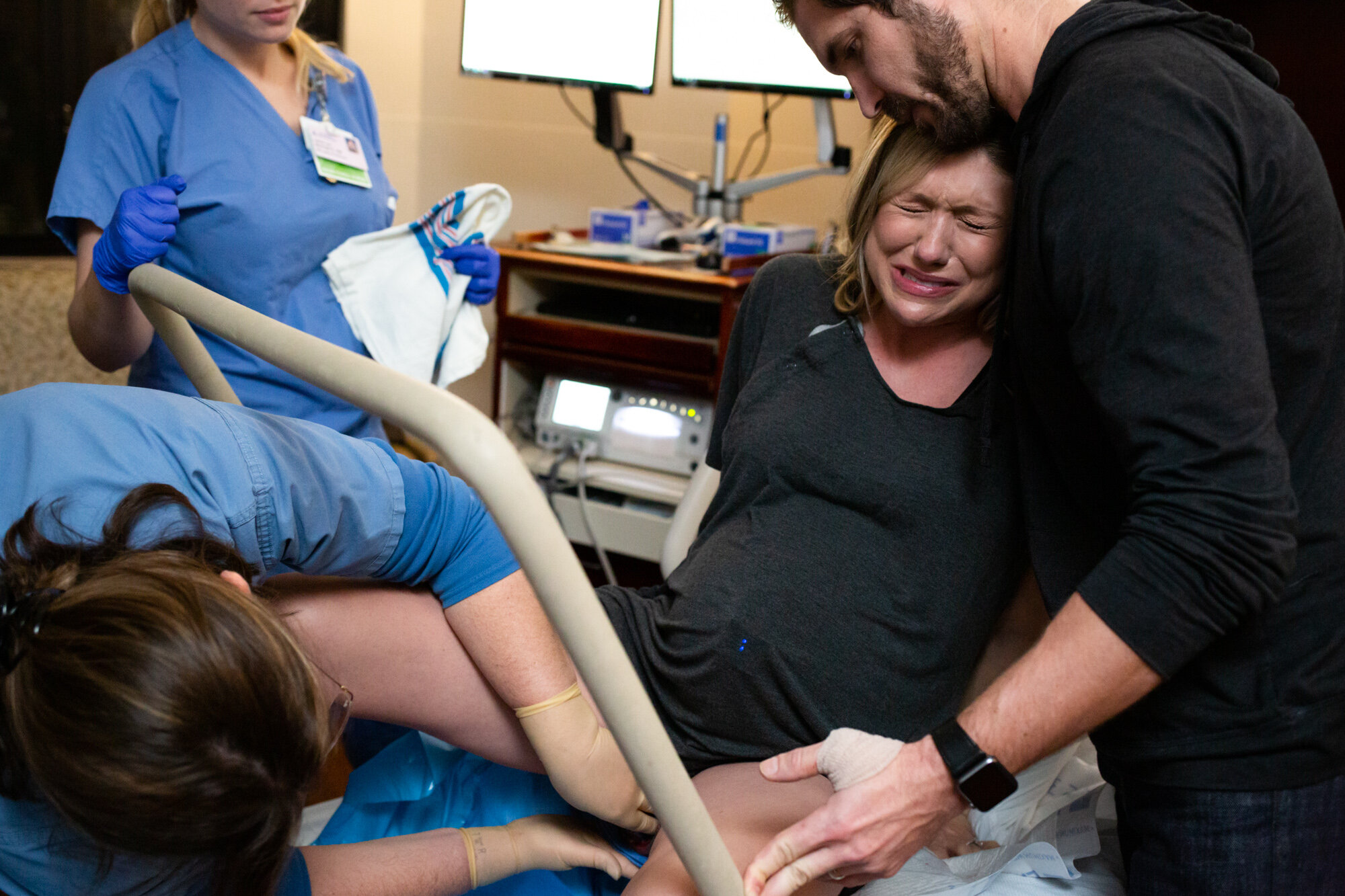 laboring mom with look of anguish as she pushes her baby down