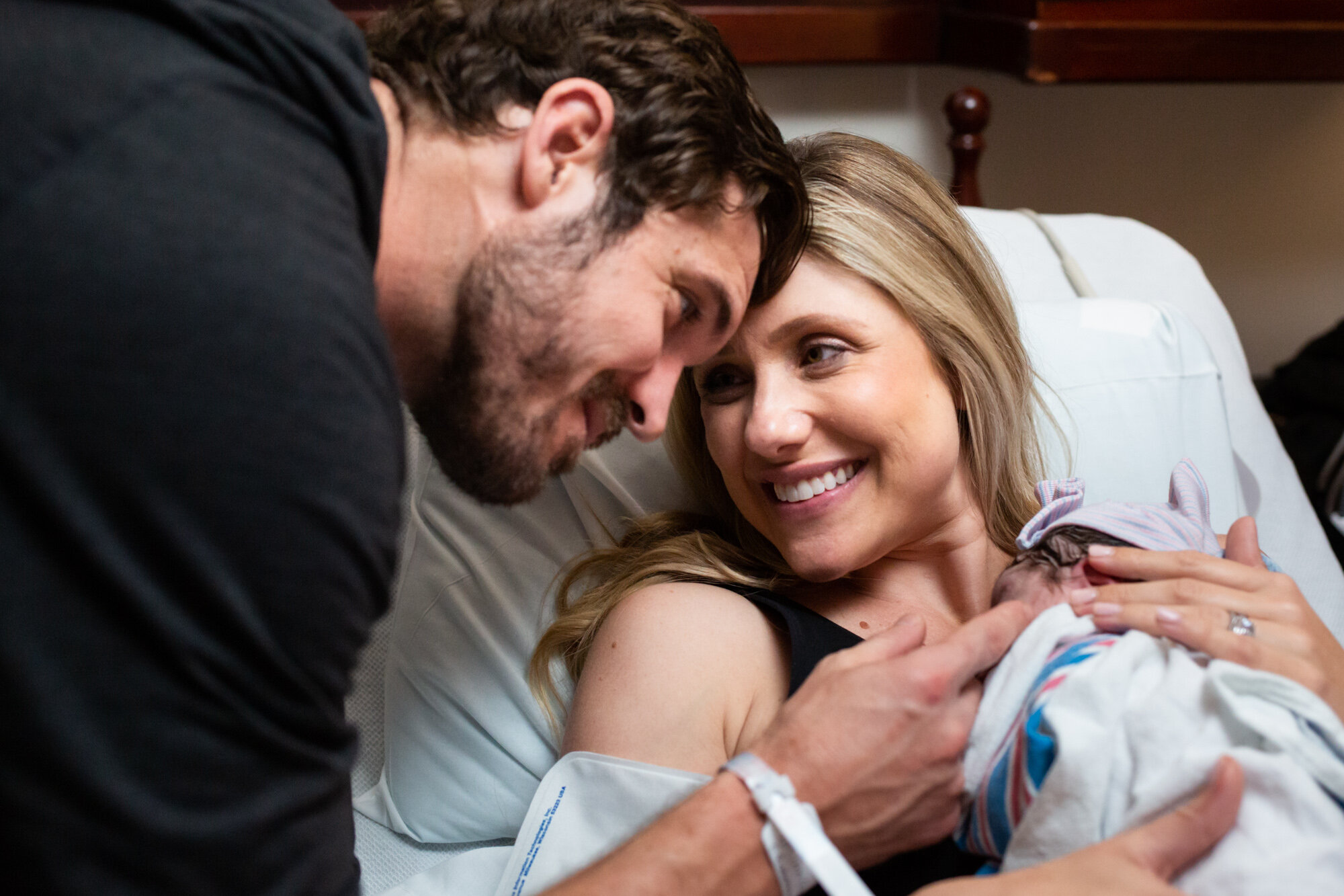 birth mom smiling at her husband after baby was born