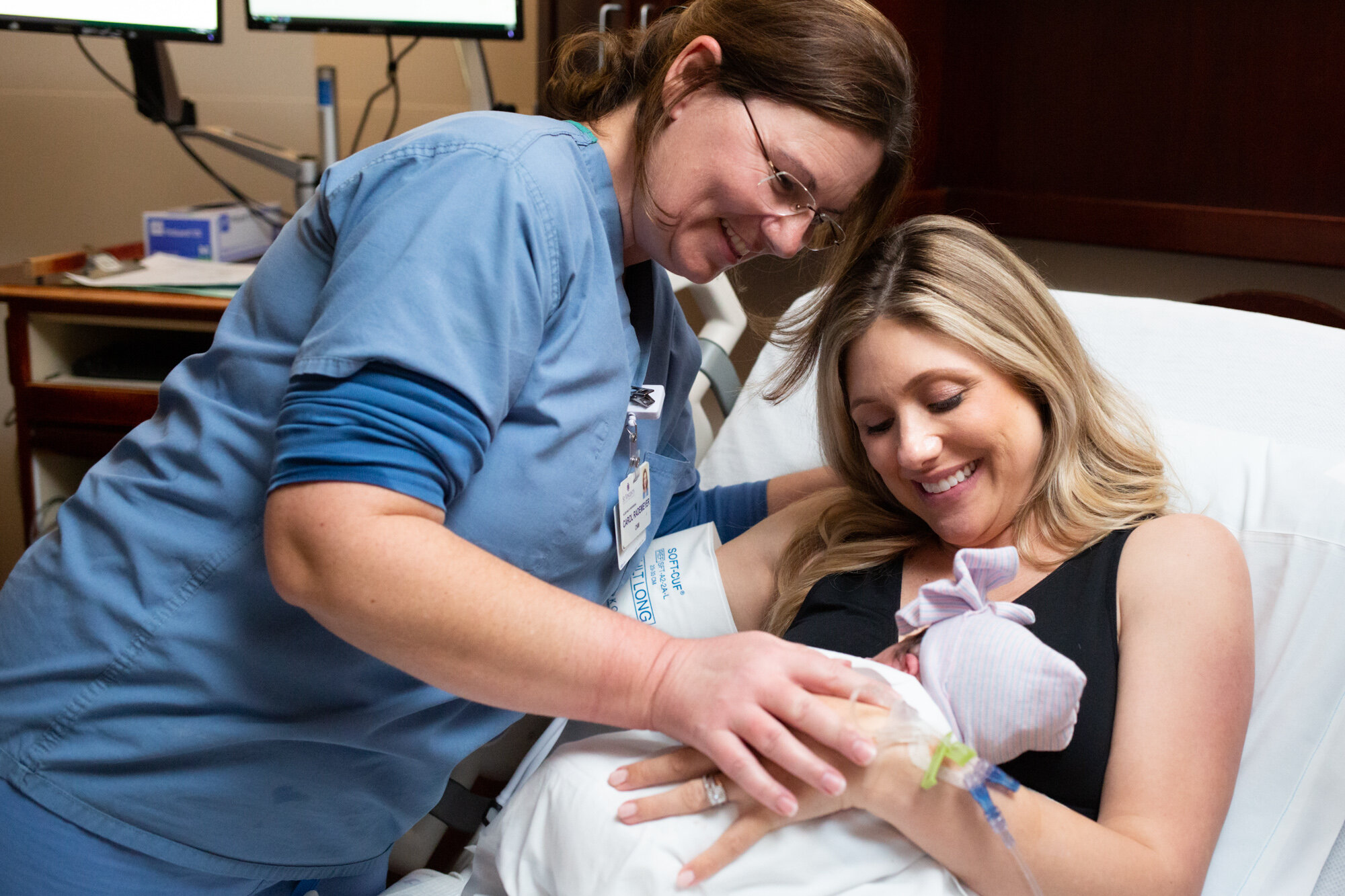 midwife smiling at newborn baby
