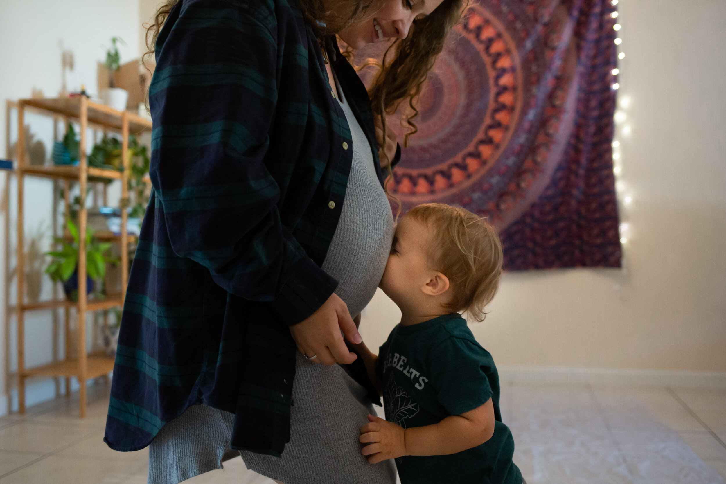 little boy kissing mom's pregnant belly