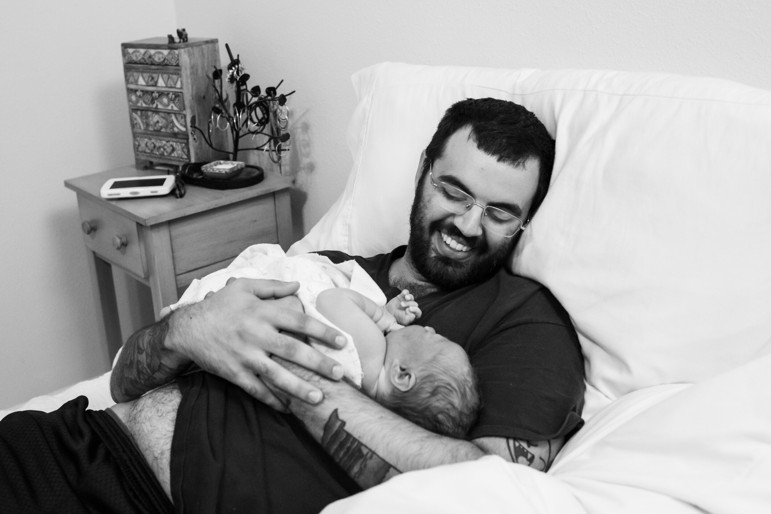 new dad smiling at newborn baby boy