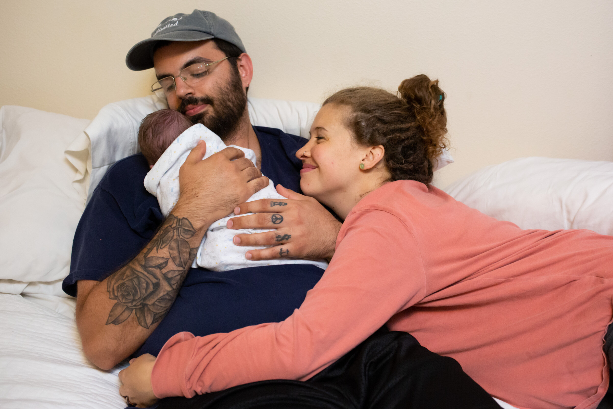 st. augustine mom hugging her partner who is holding their baby just after birth