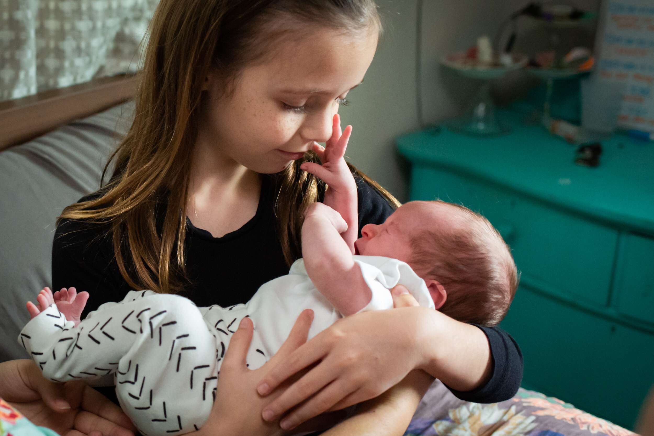 child holding her newborn baby sister