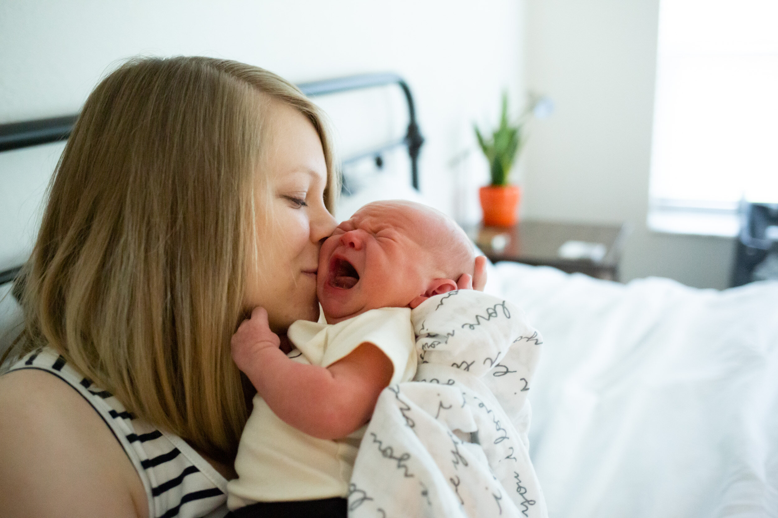 new mom kissing her baby boy