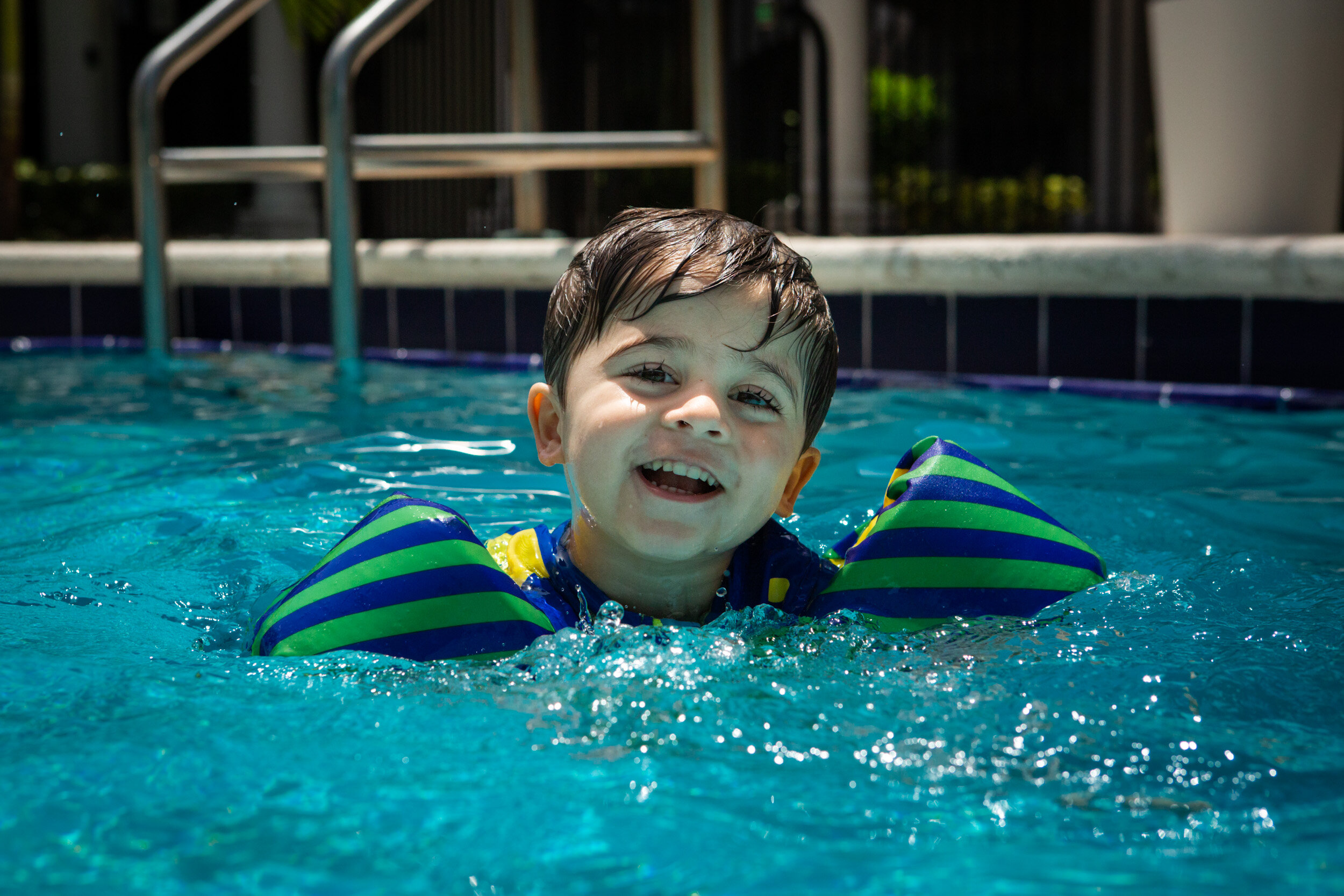little boy smiling while swimming