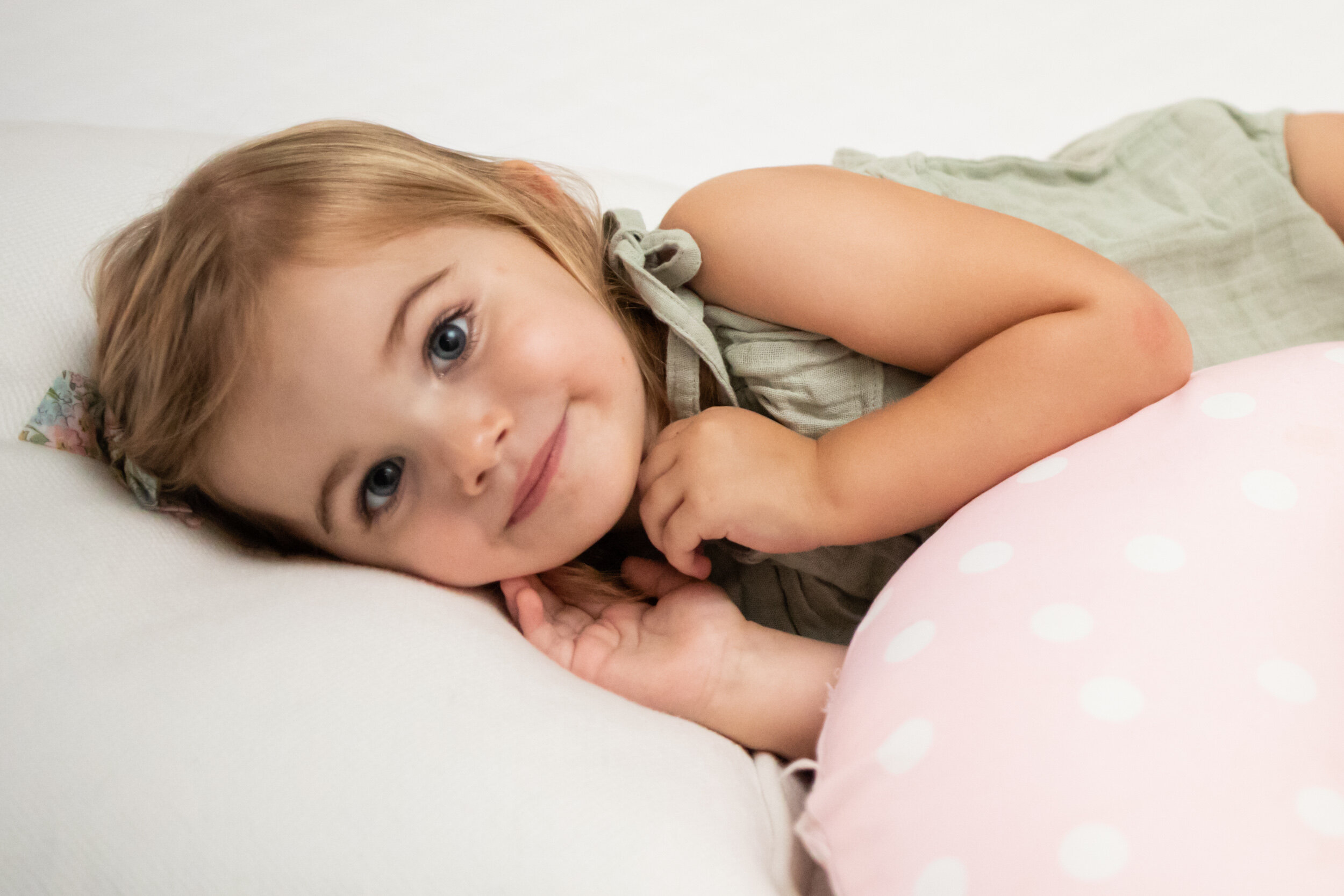 young girl snuggled up on her parents' bed