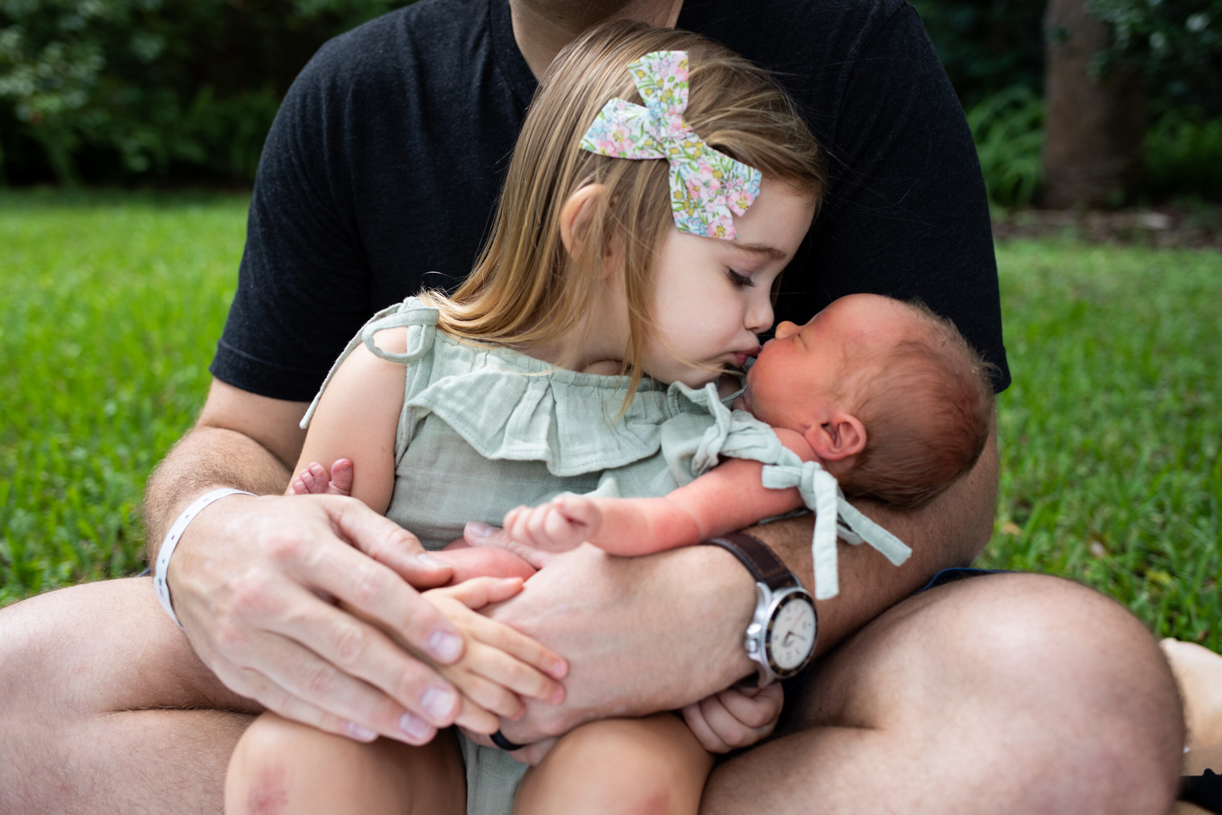 big sister kissing baby sister