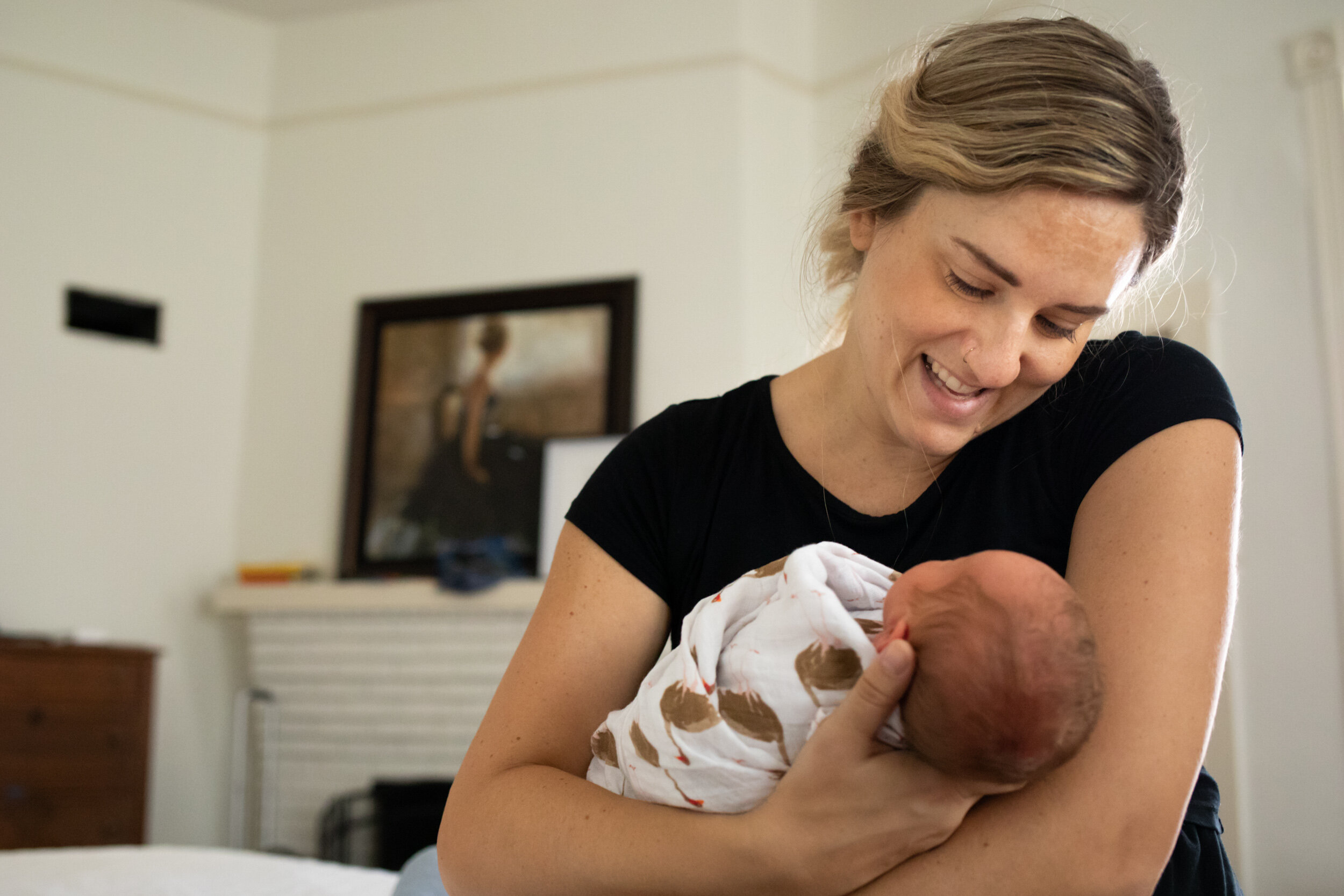 mom smiling at her newborn baby girl