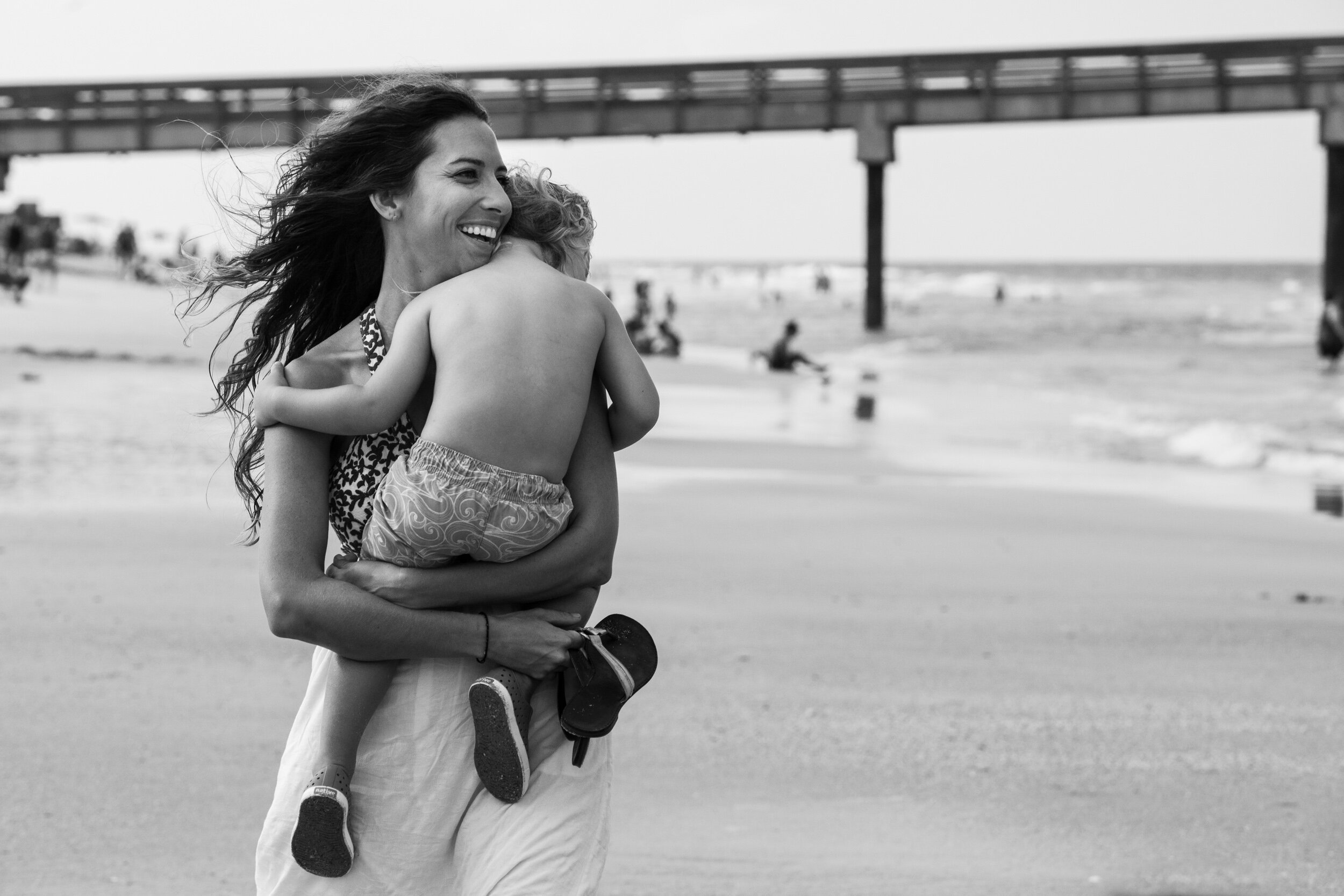 mom holding son walking on the beach in anastasia island, florida