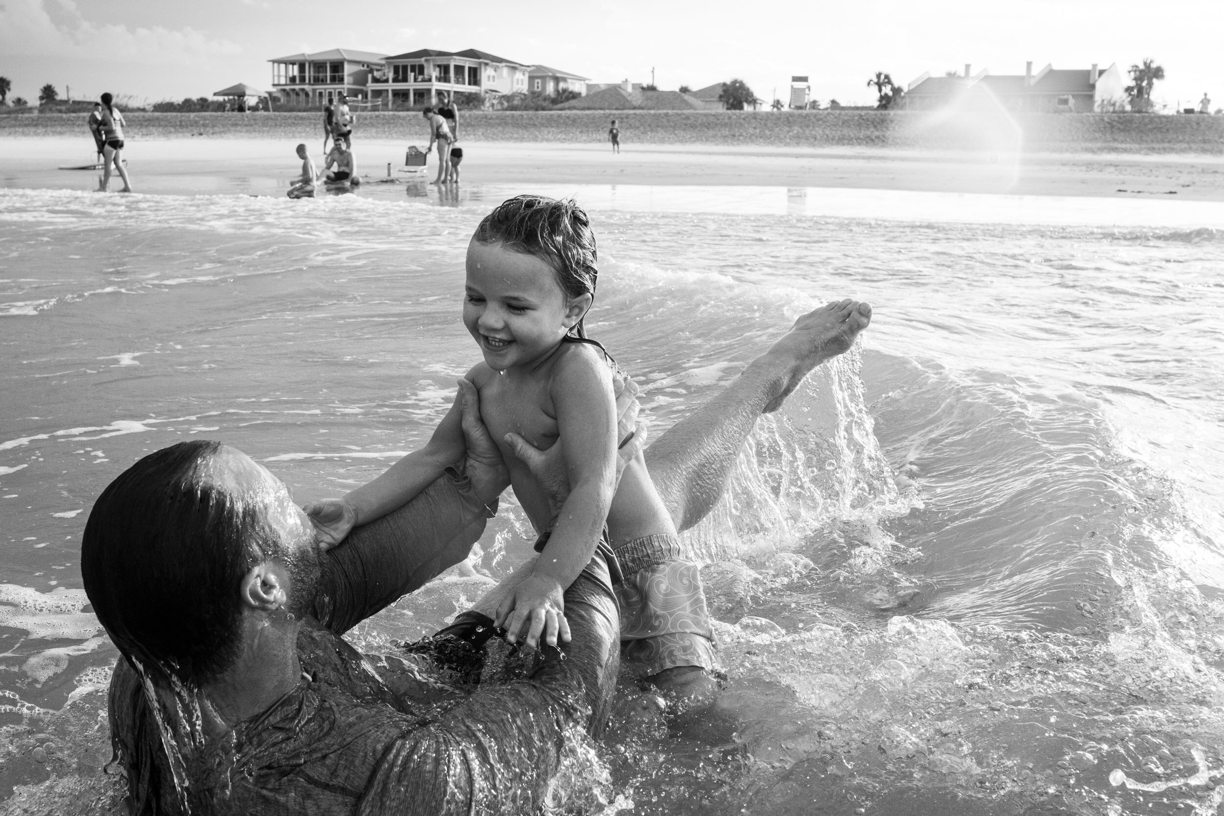 dad and little boy in the water at the beach