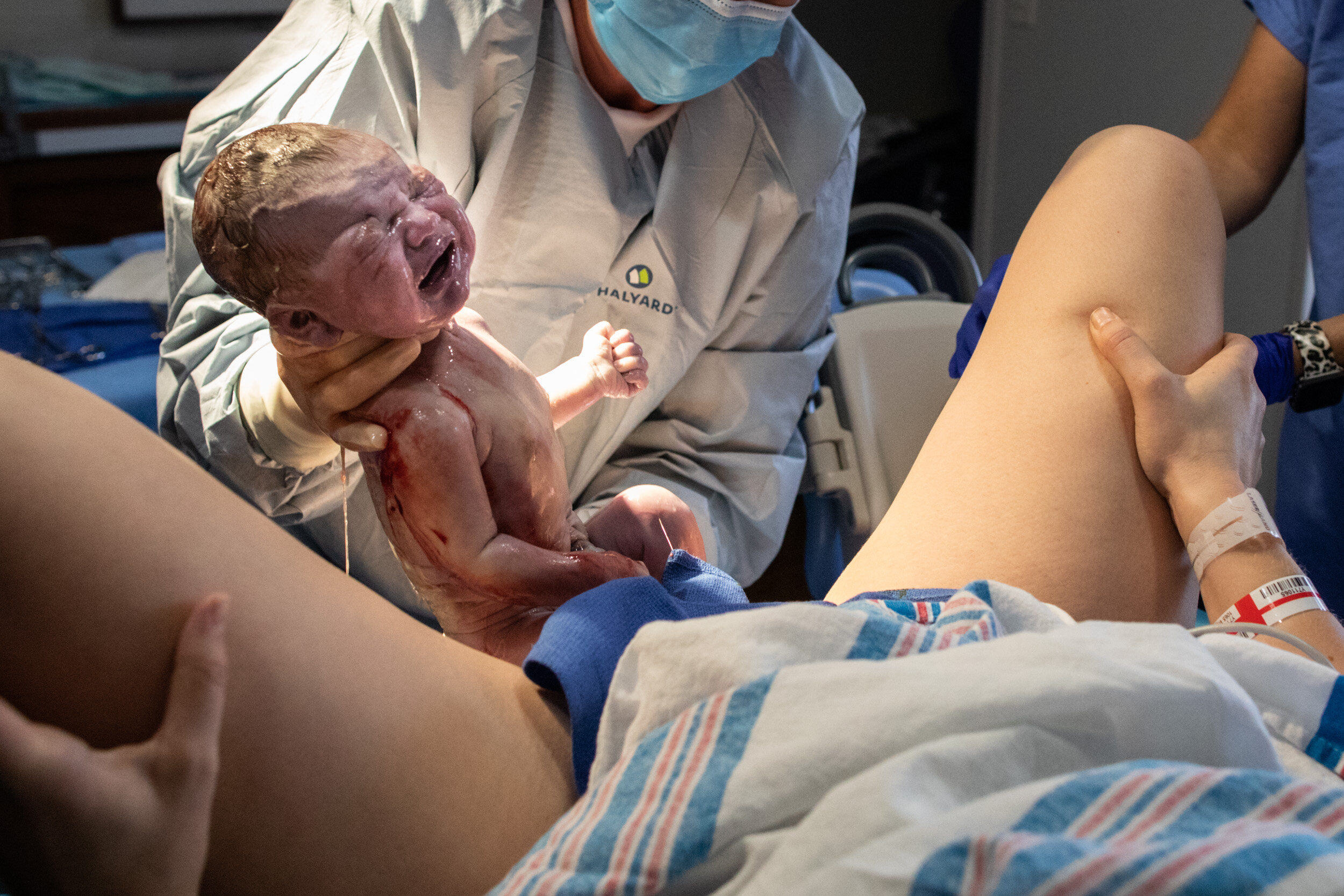 baby being held up by the doctor after birth