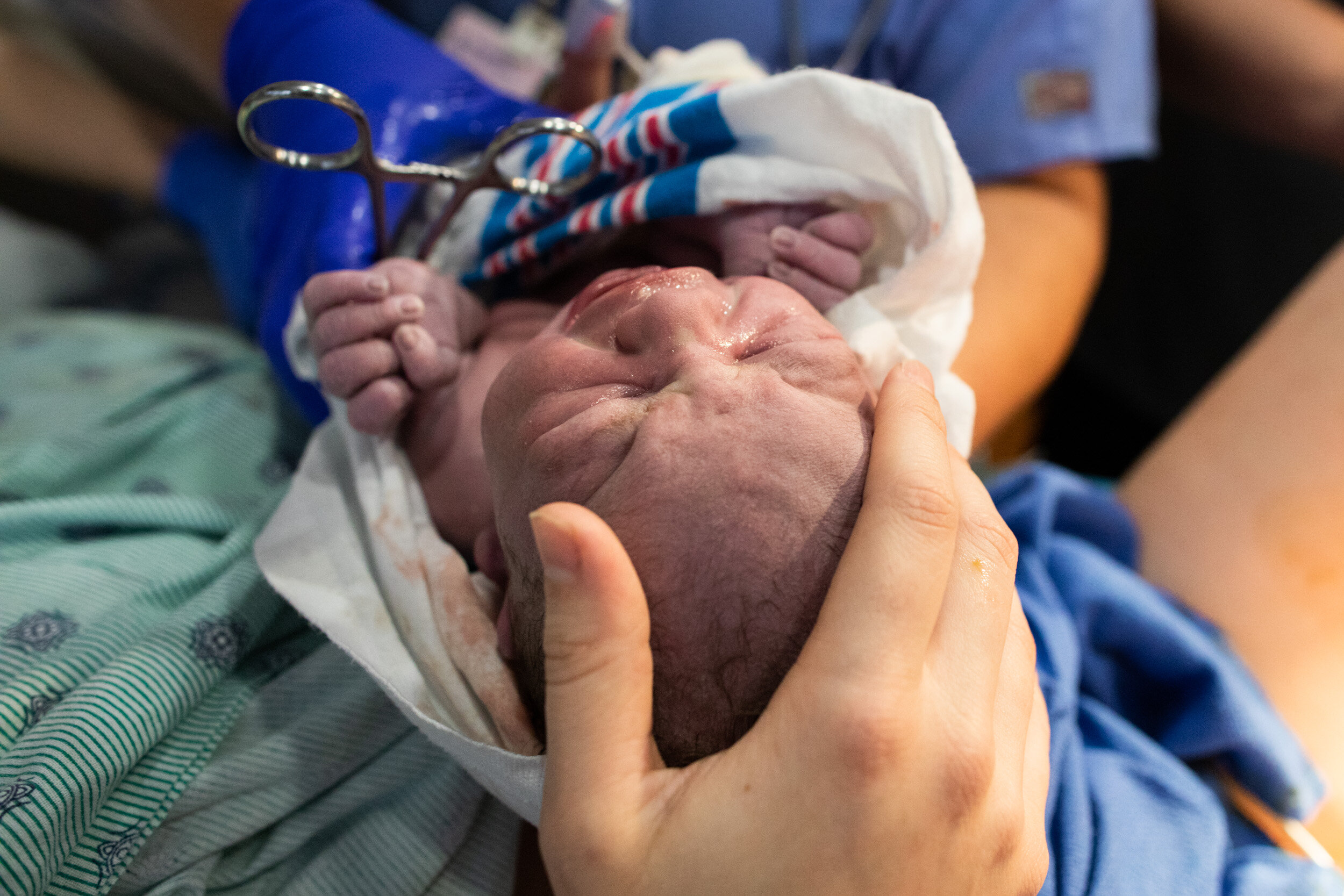 jacksonville birth mom touching her baby boy's head for the first time