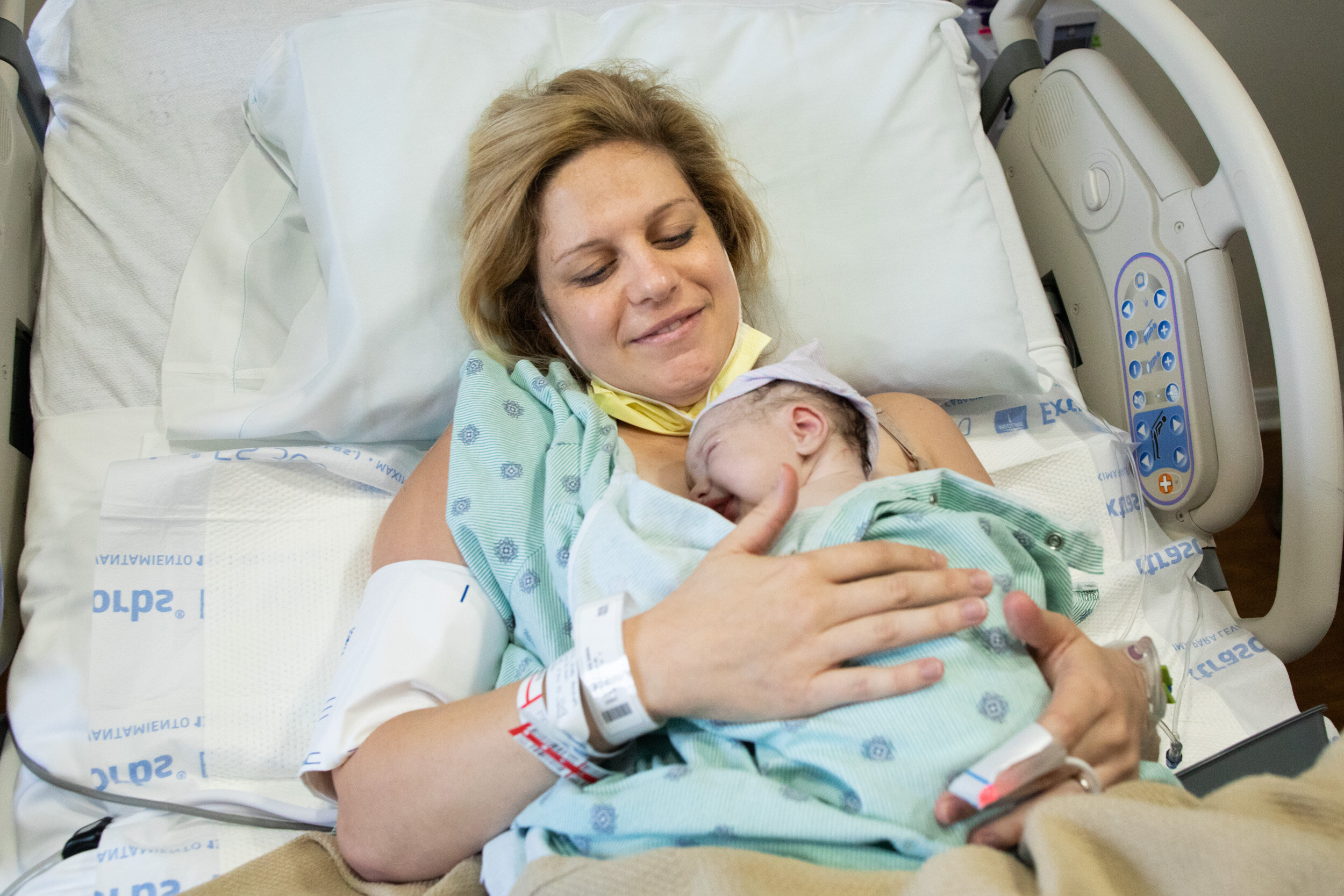 birth mom with a look of relief while holding her newborn baby just after he was born