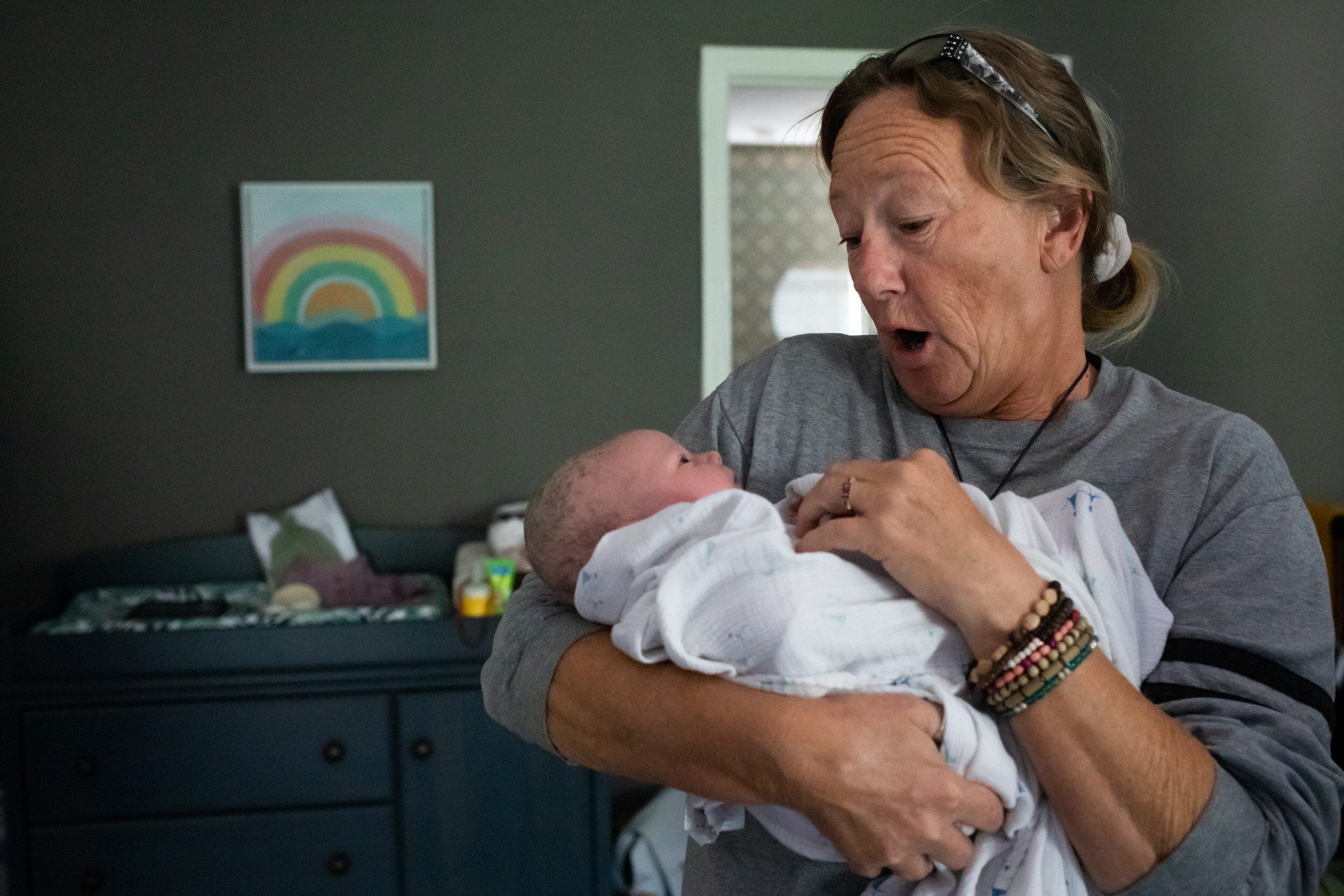 grandmother holding her newborn baby granddaughter