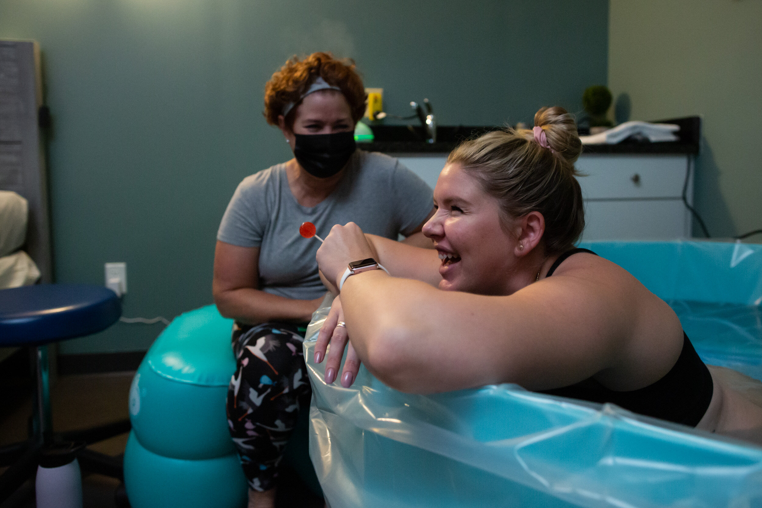 birth mom smiling while in birth pool at birth center