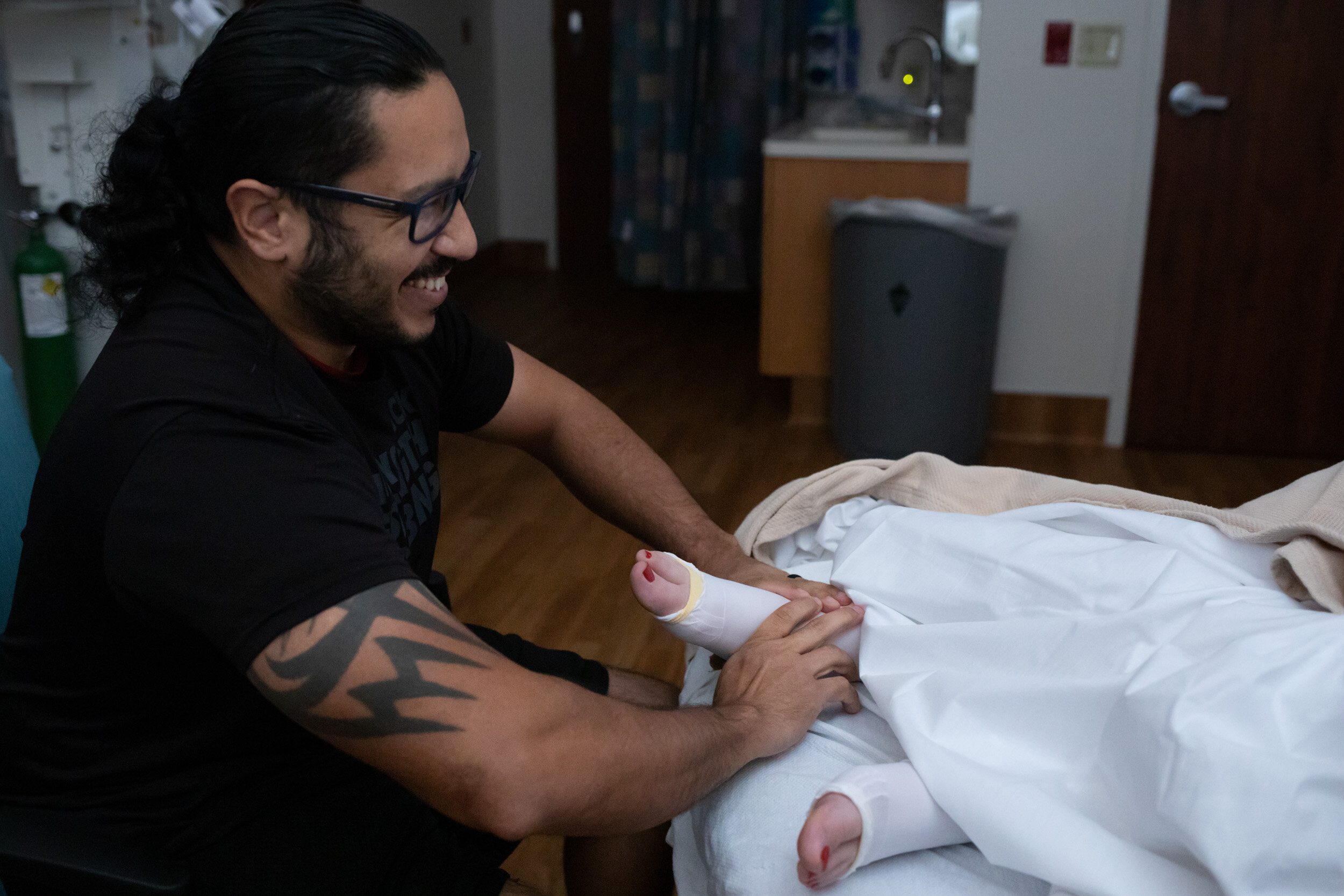 husband giving foot rub to pregnant wife in the hospital