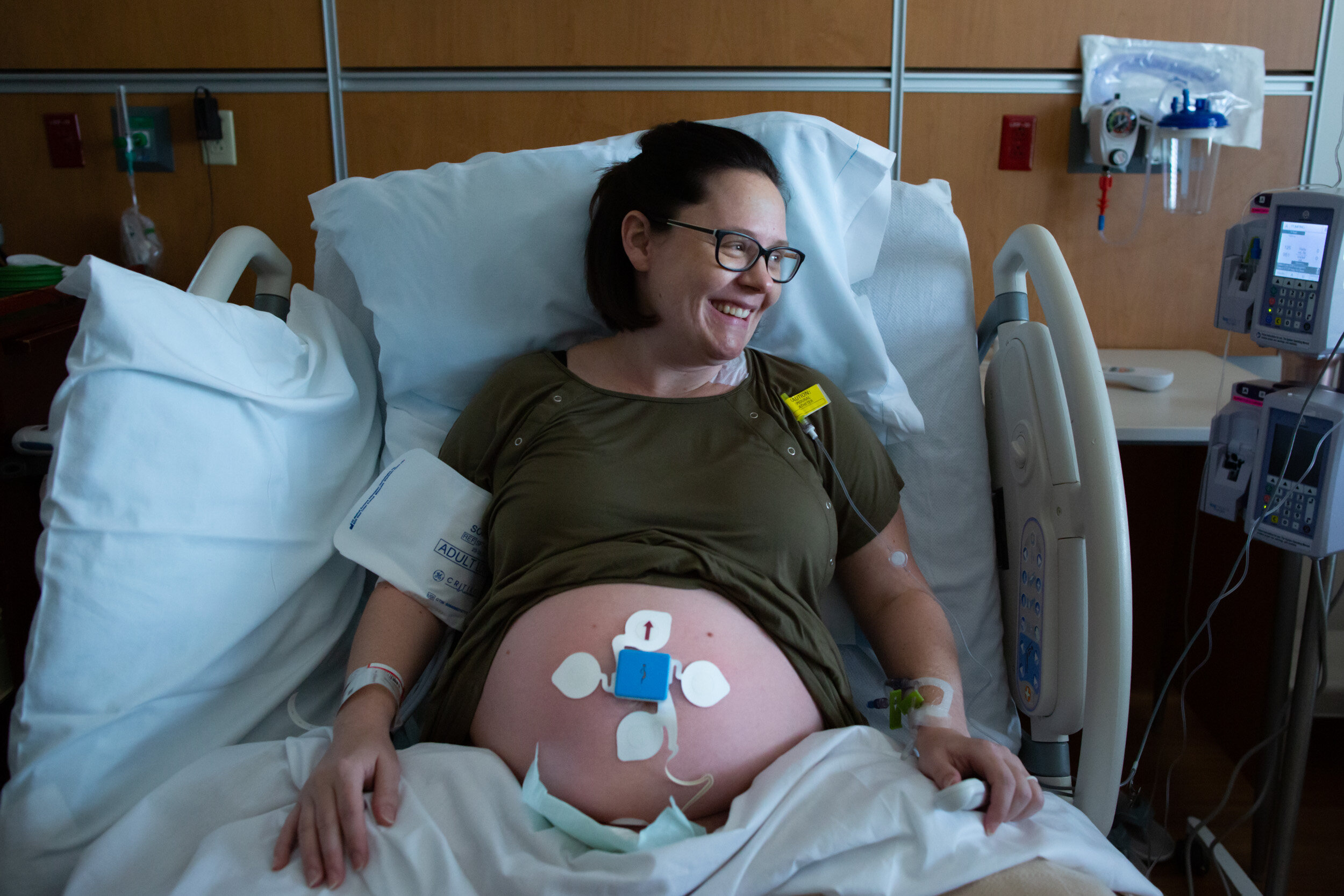 new mom in hospital bed with pregnant belly out