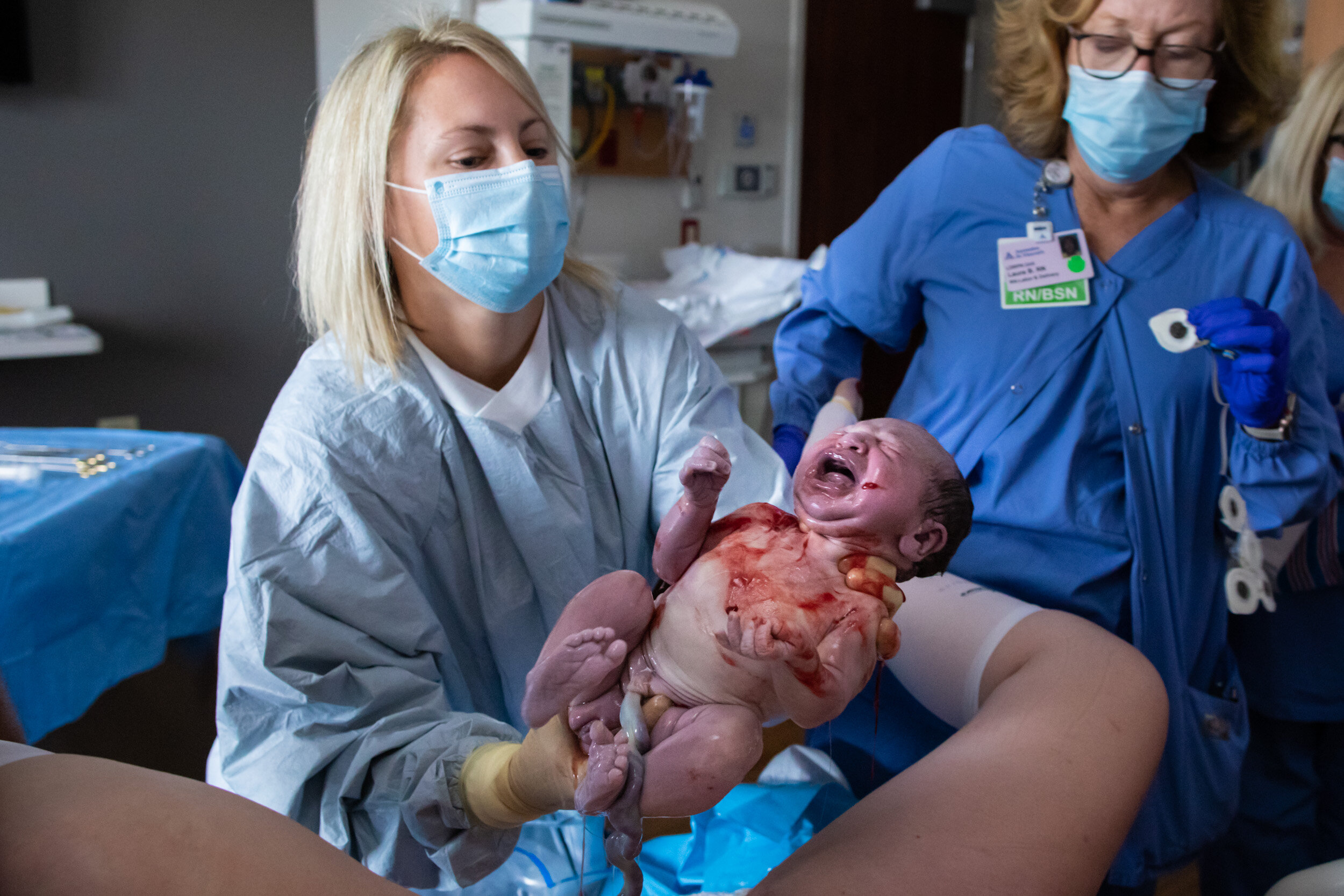 Jacksonville midwife lifting baby to birth mom