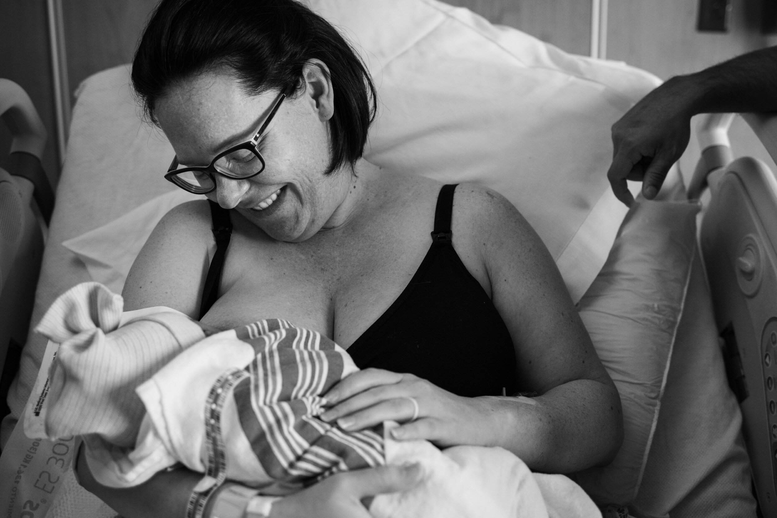 mom smiling at her newborn baby girl just after birth