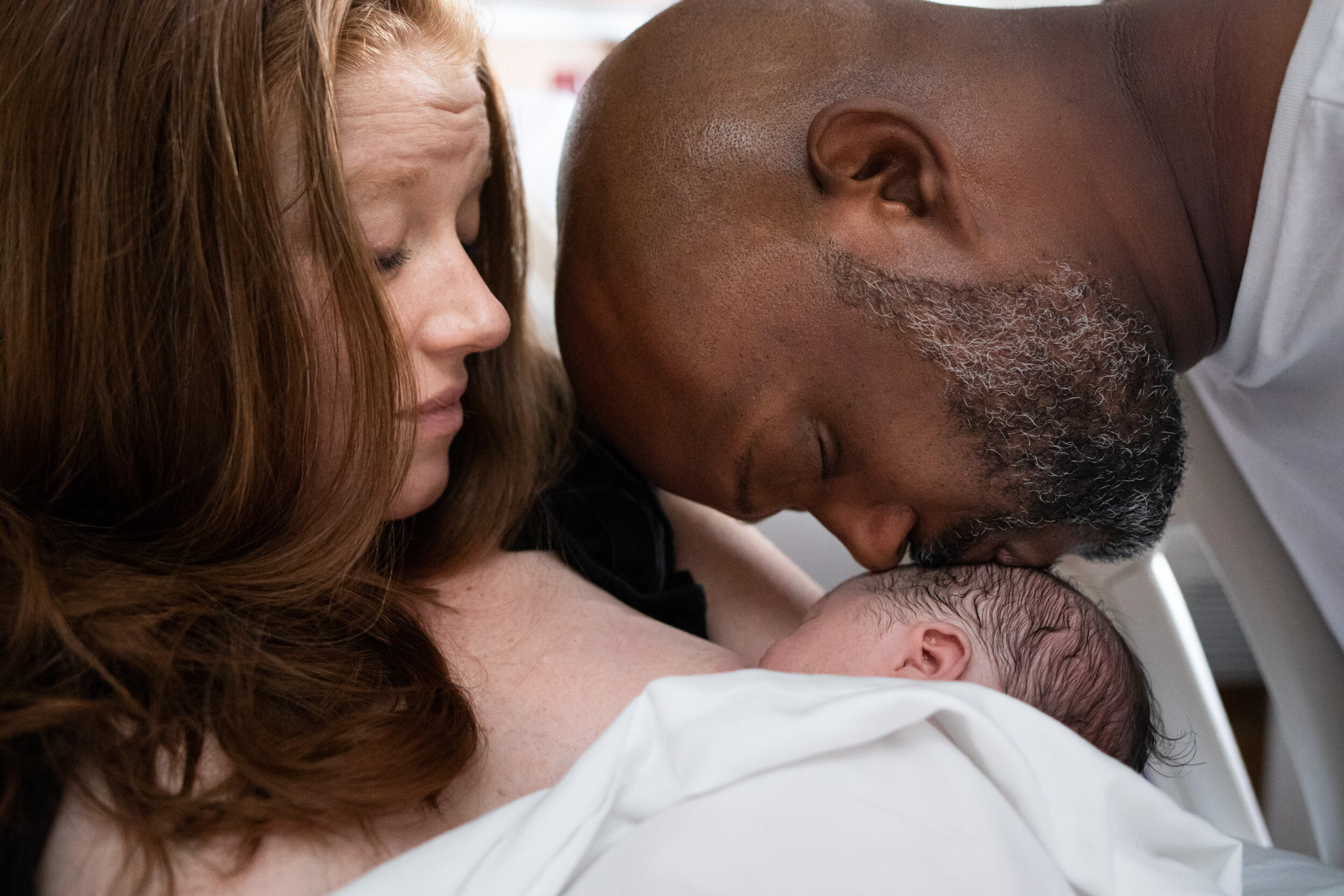 Jacksonville dad kissing his newborn baby boy just after birth