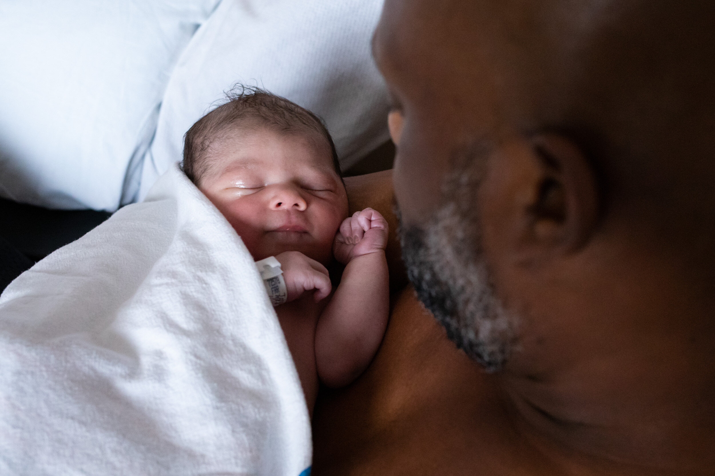 newborn baby boy being held by his dad just after birth