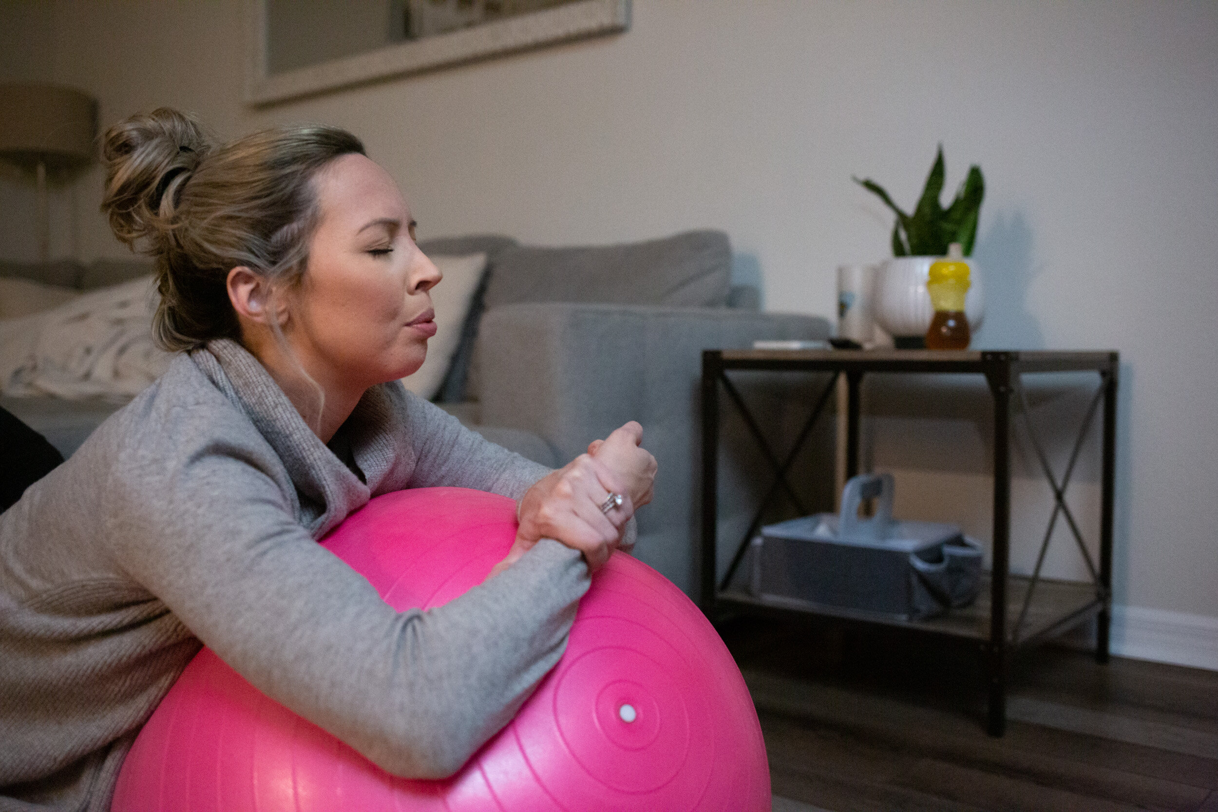 Laboring mom breathing while holding onto birth ball