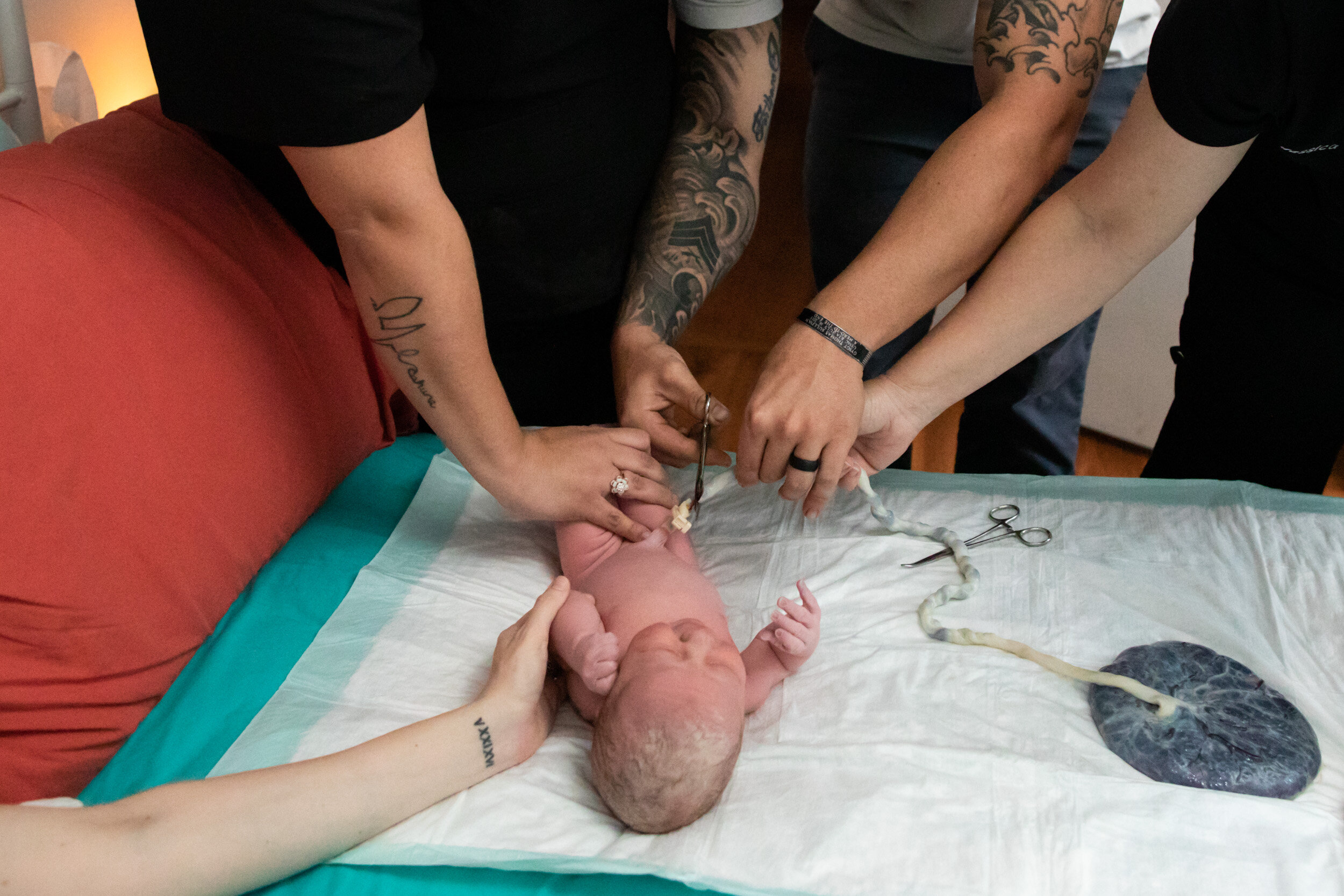 dad cutting the umbilical cord for his newborn baby girl