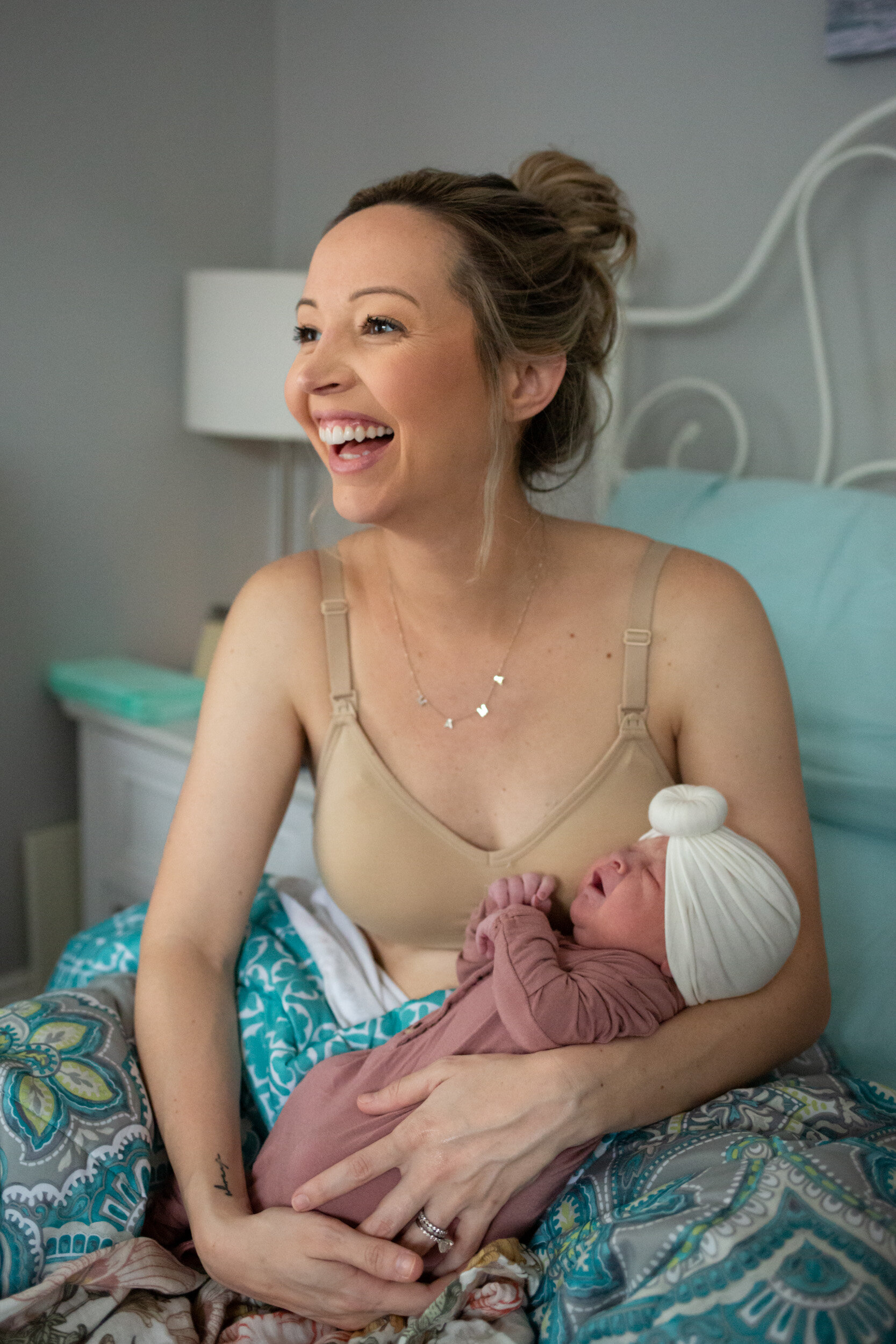 Jacksonville mom laughing while holding her baby just after birth