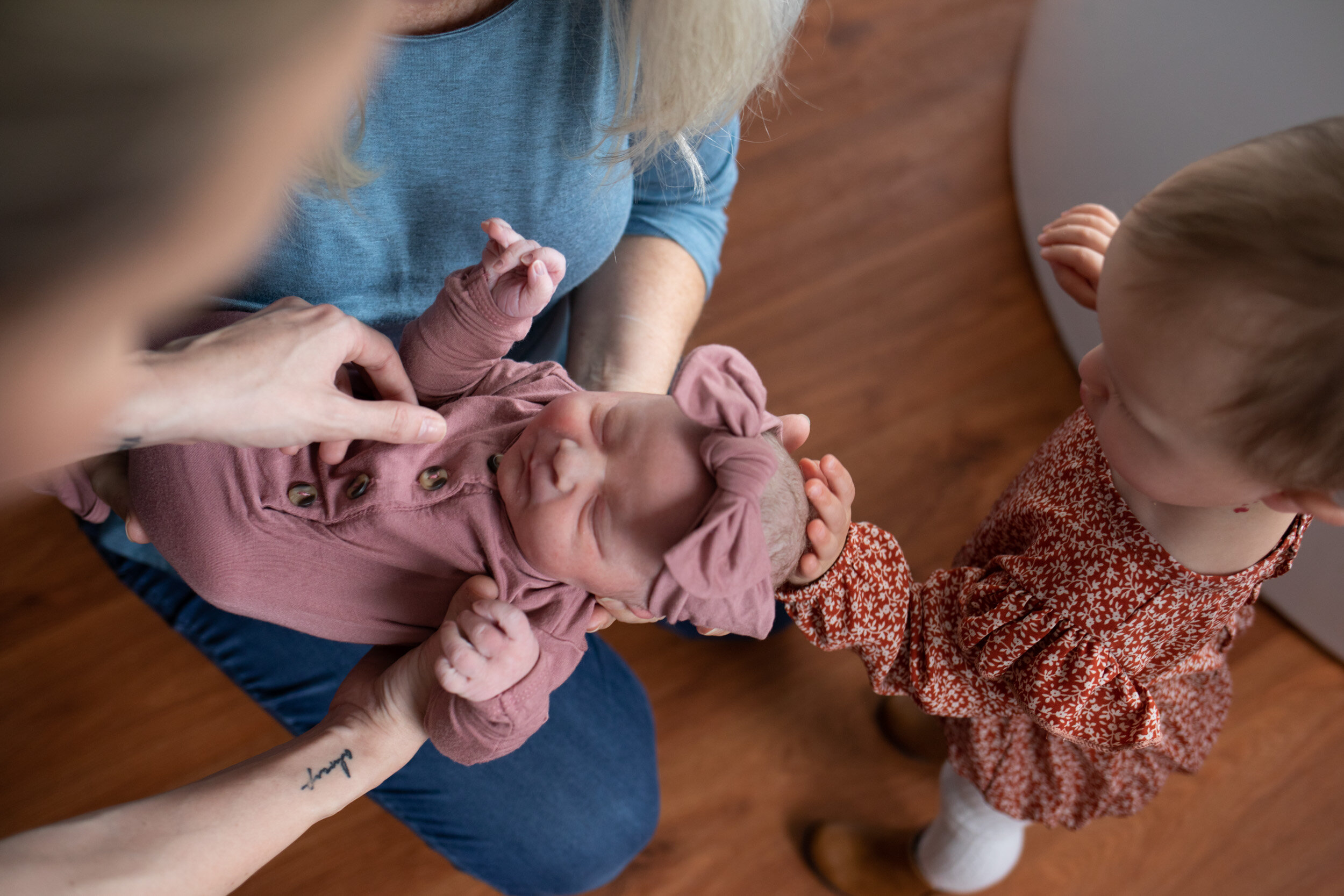 Toddler touching her newborn baby sister's head