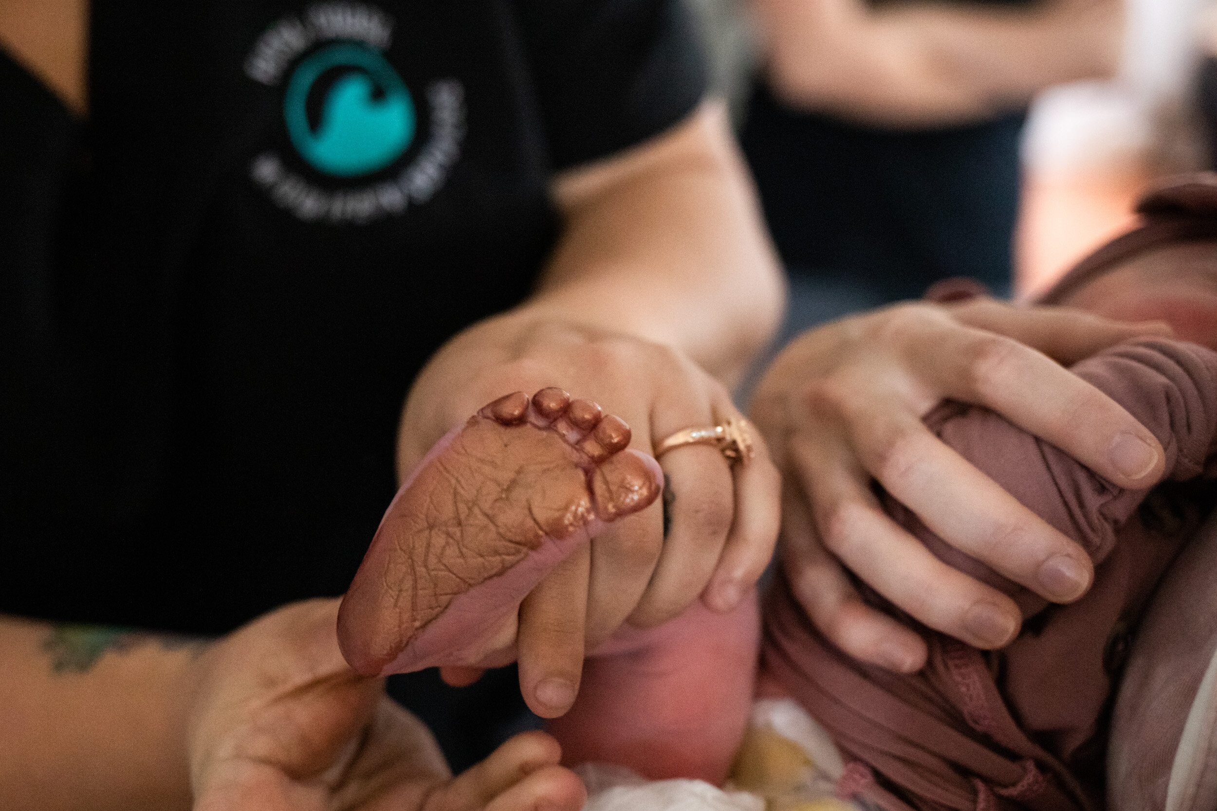 Midwife holding baby foot for footprint