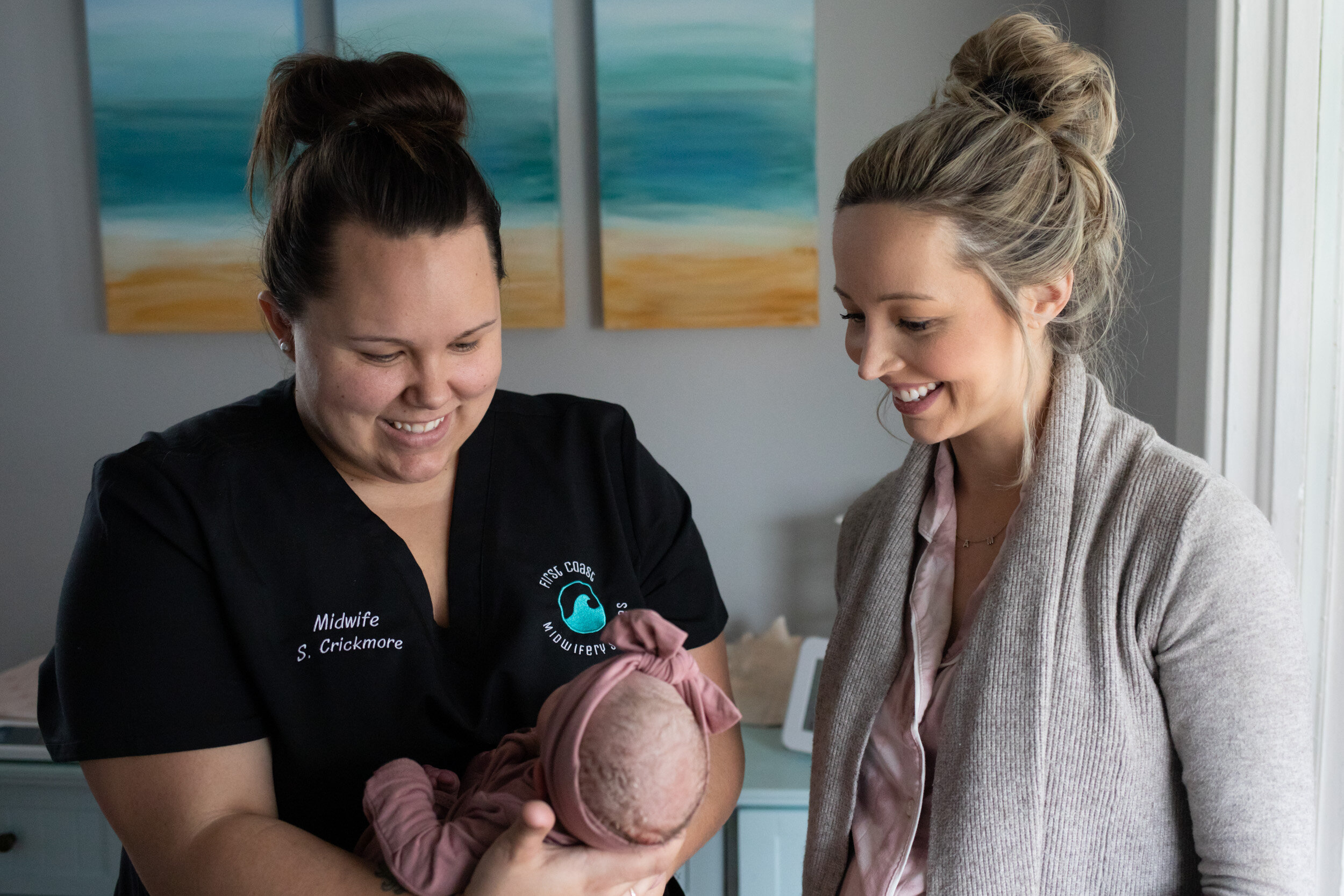Midwife Sam and new mom smiling at baby girl just after birth