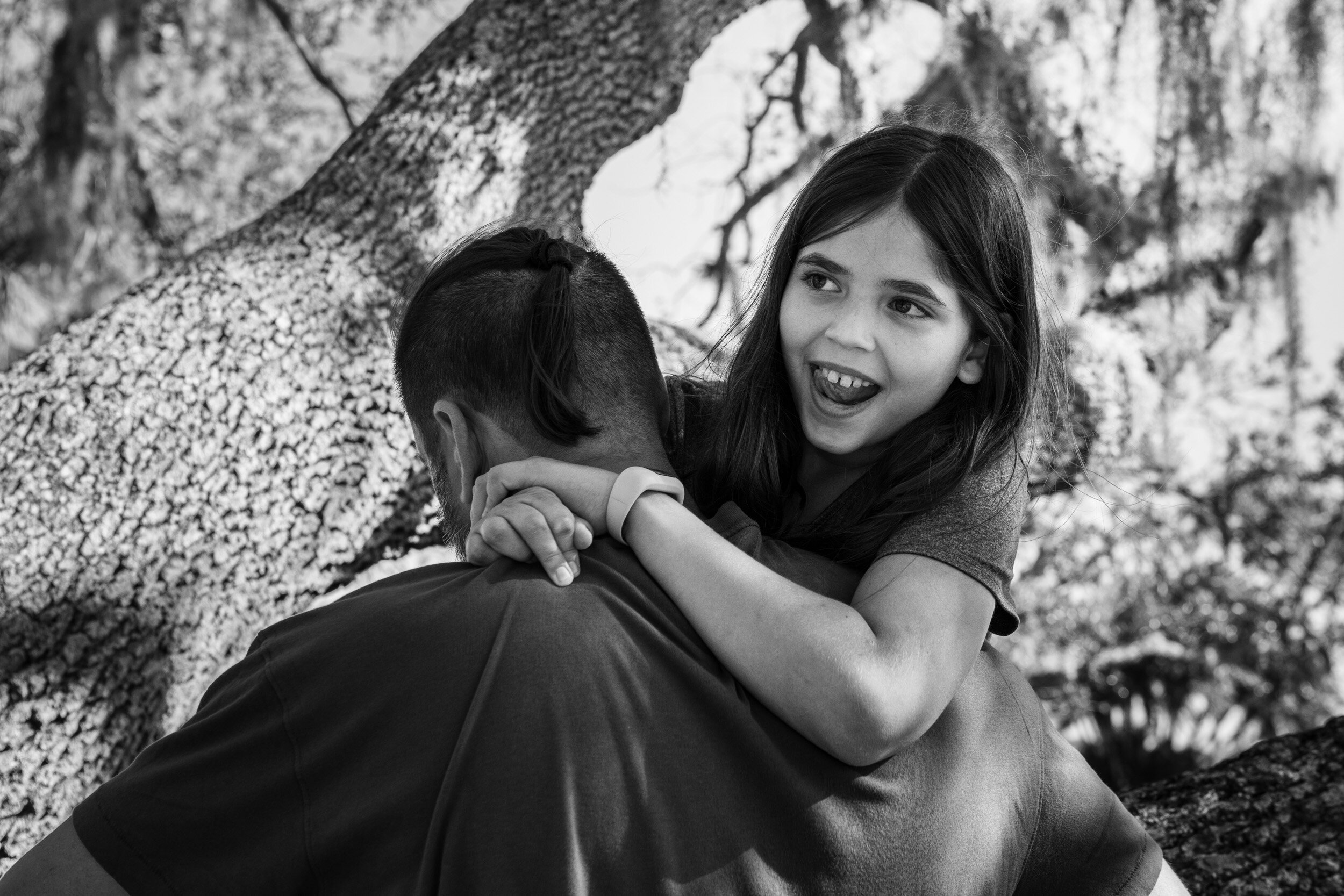 Girl holding onto her dad and laughing