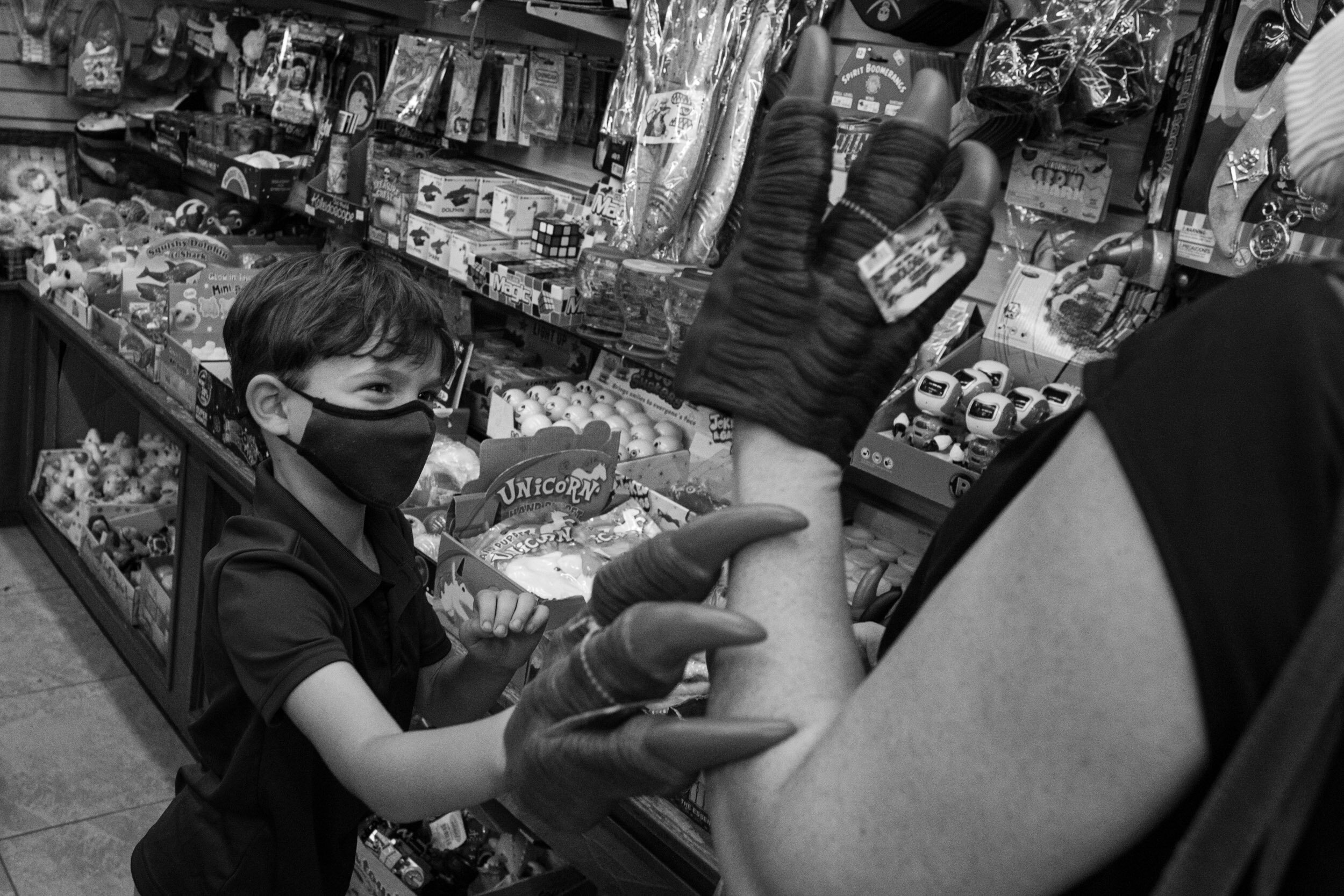 little boy using a fake claw in a store