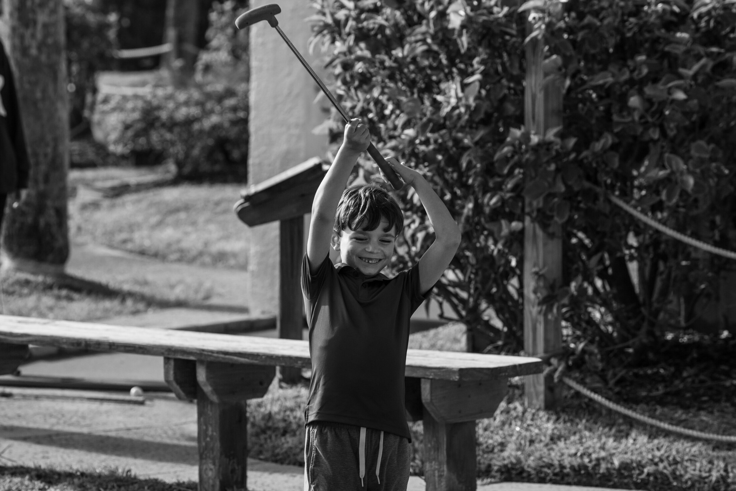 little boy raising up a golf club