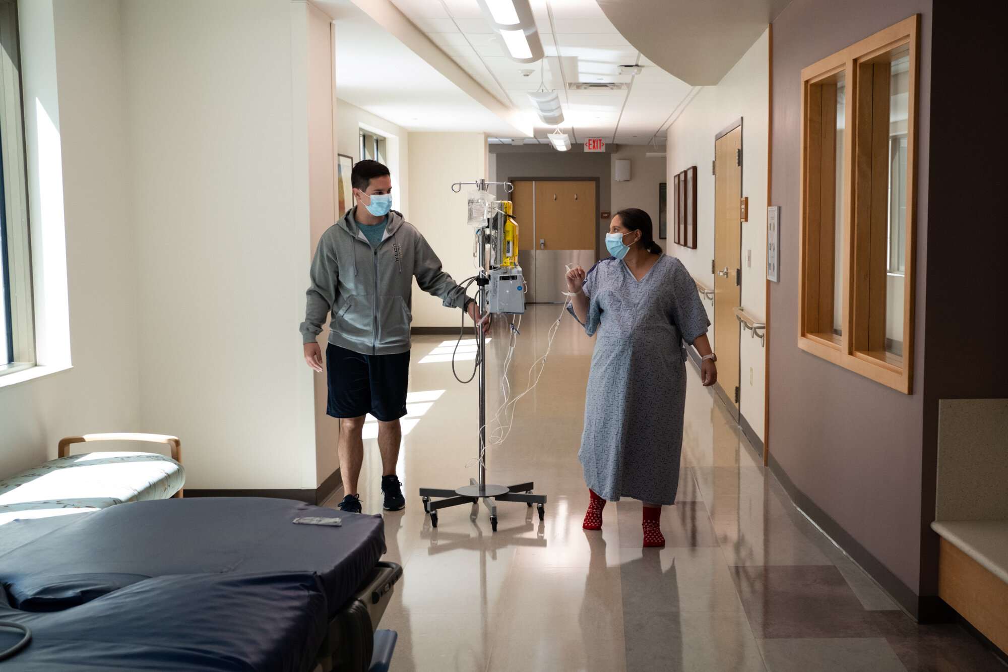 pregnant mom and her husband walking in hospital hallway