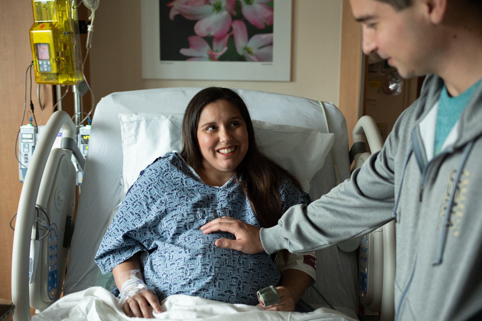 pregnant mom smiling at husband as he feels their baby while she's in labor