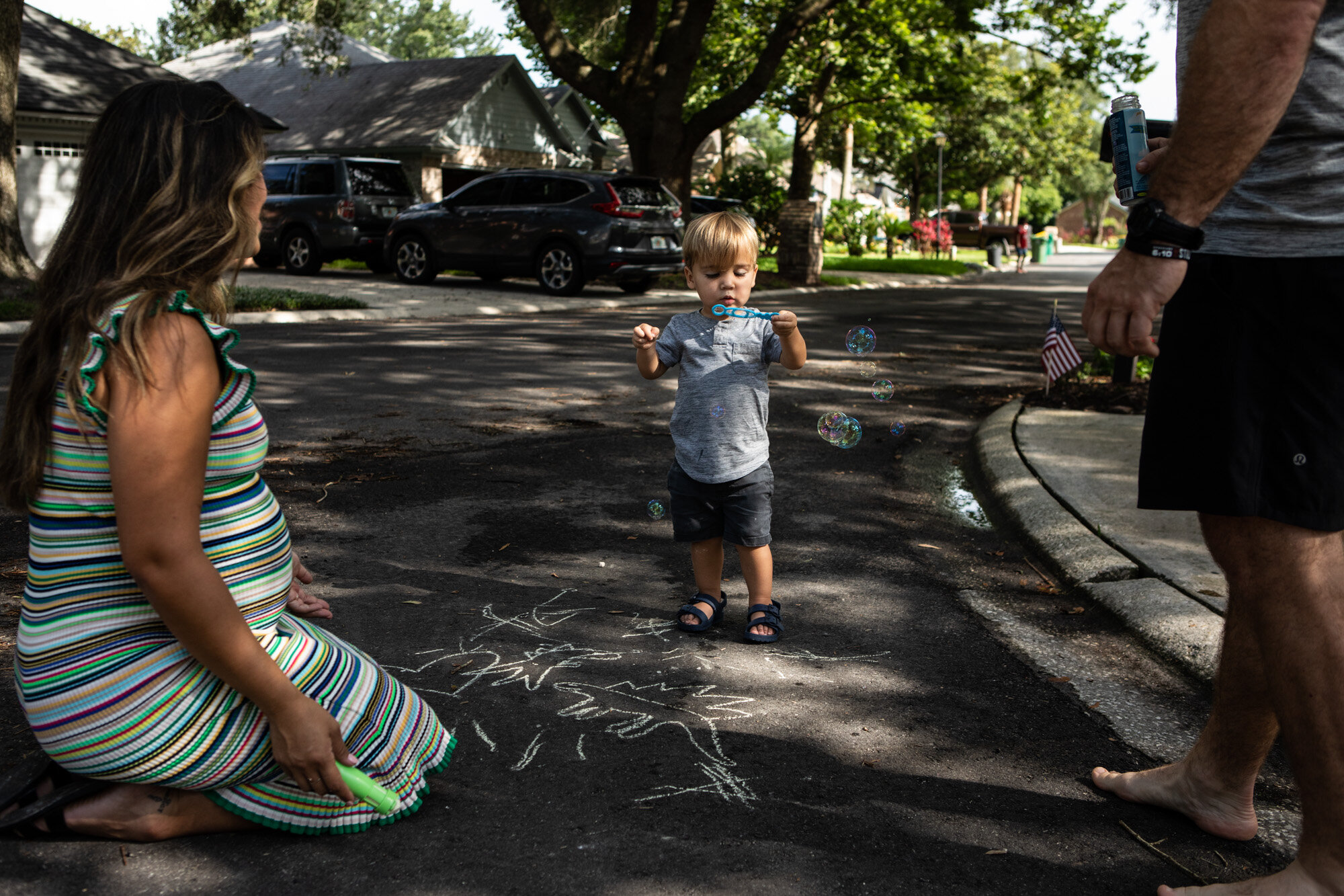 little boy blowing bubbles on street in jacksonville beach