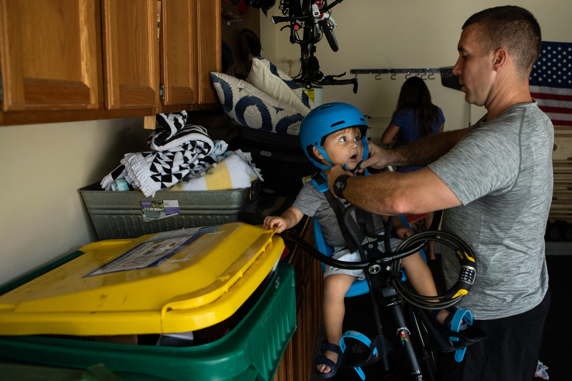 little boy looking at dad as he straps his helmet on