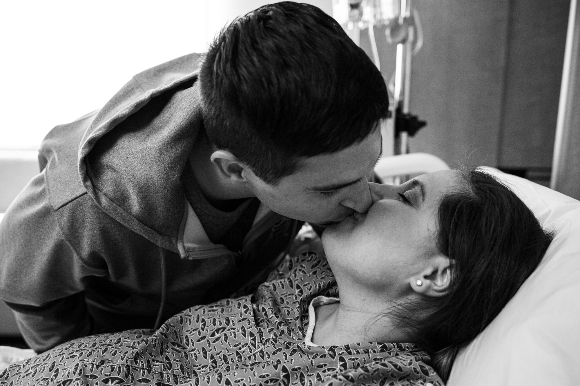 husband and wife kissing while awaiting the arrival of their baby at the hospital