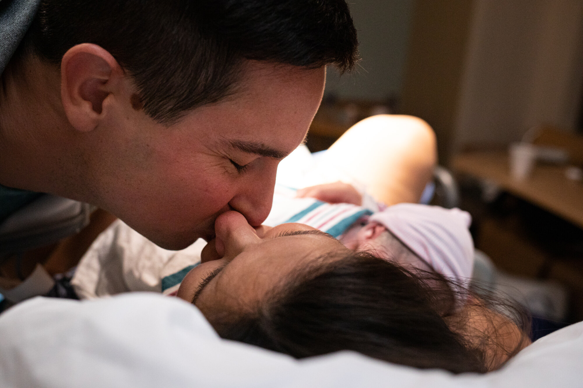 jacksonville parents kissing after the birth of their baby boy