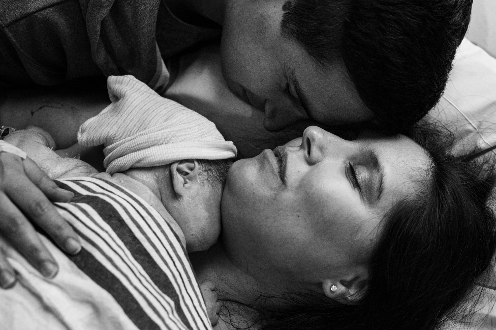 jacksonville birth parents snuggling close with their newborn baby boy just after birth