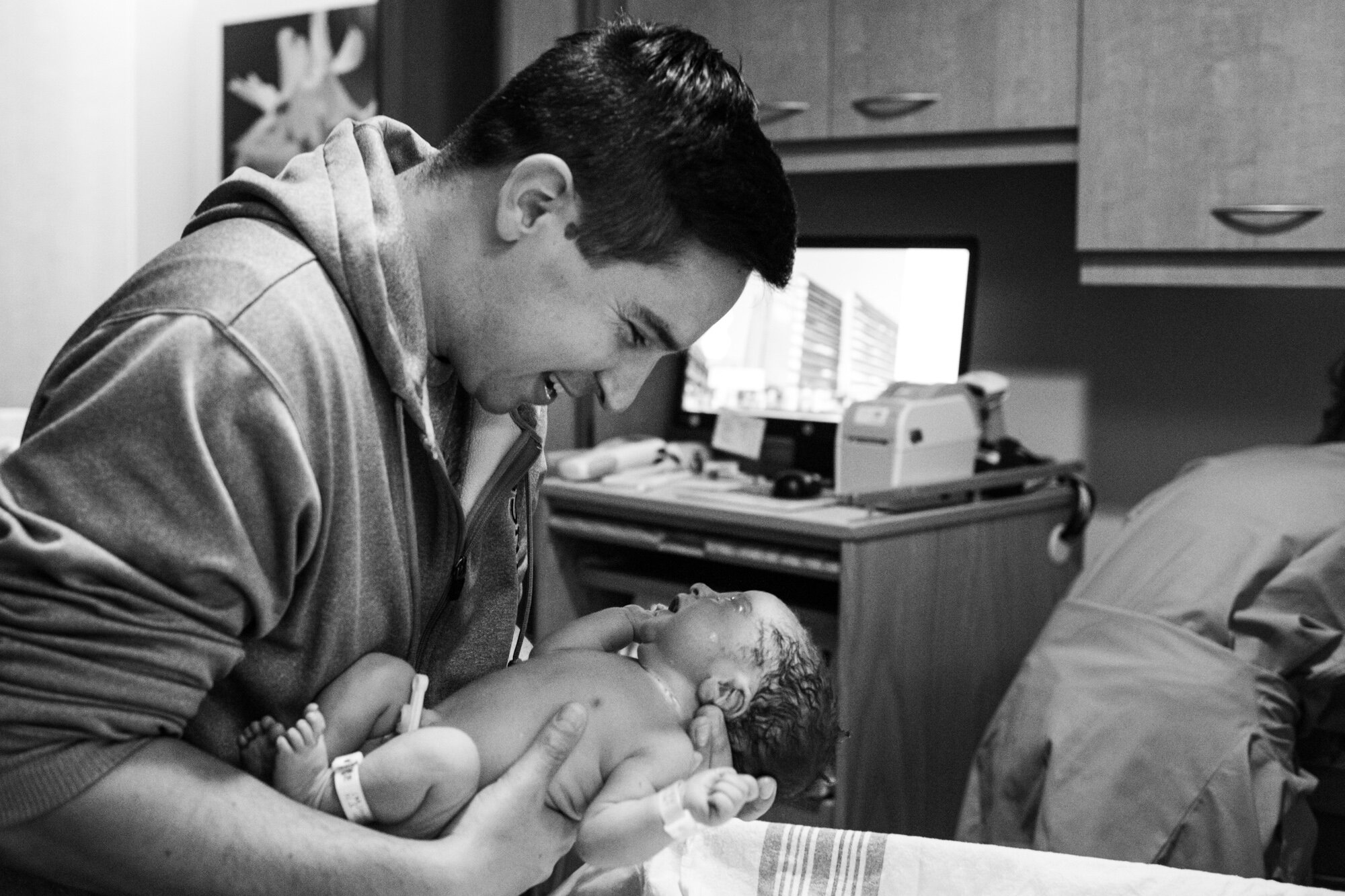 new dad holding his baby for the first time after birth