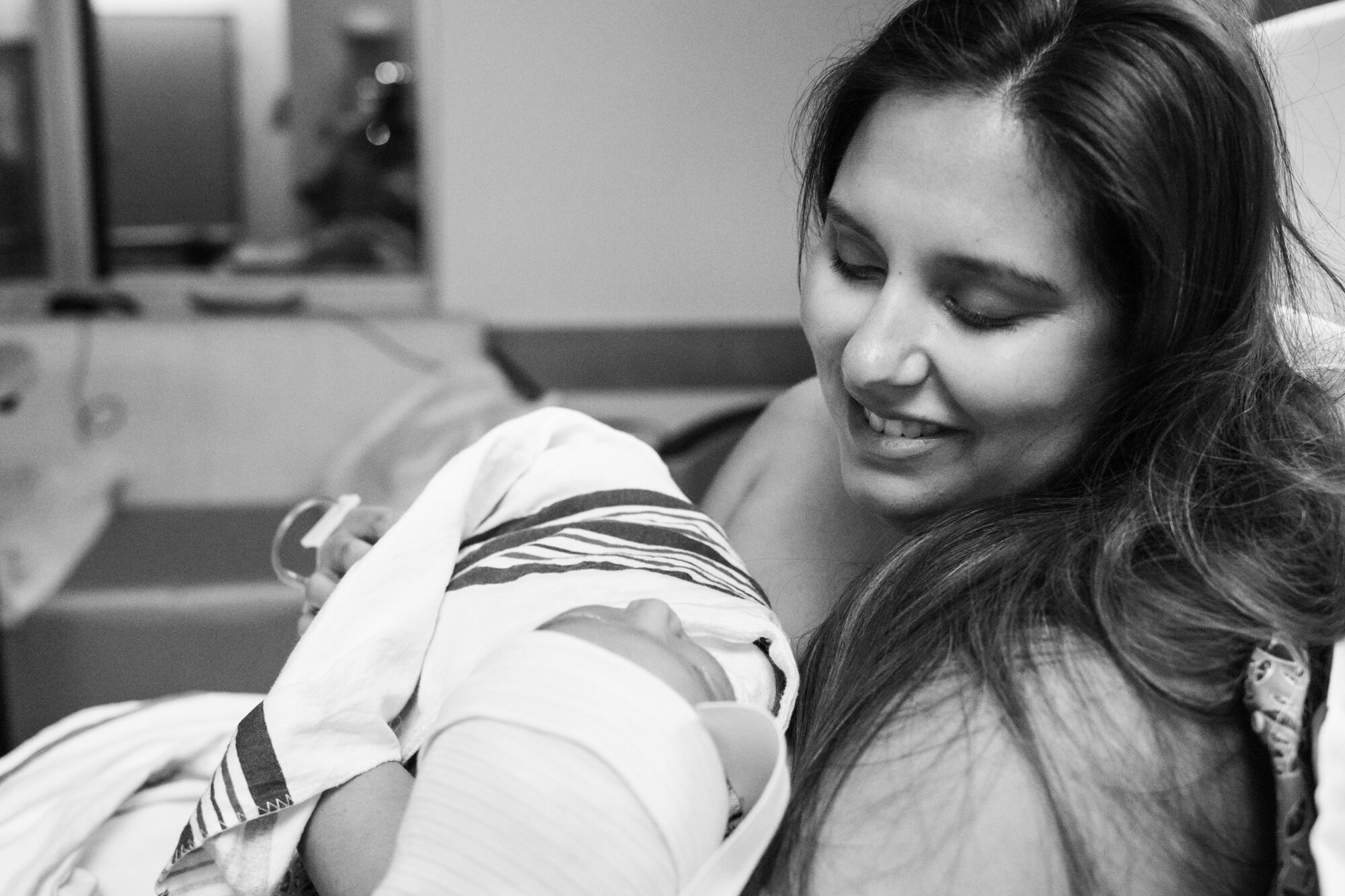 new mom smiling at her baby boy just after birth