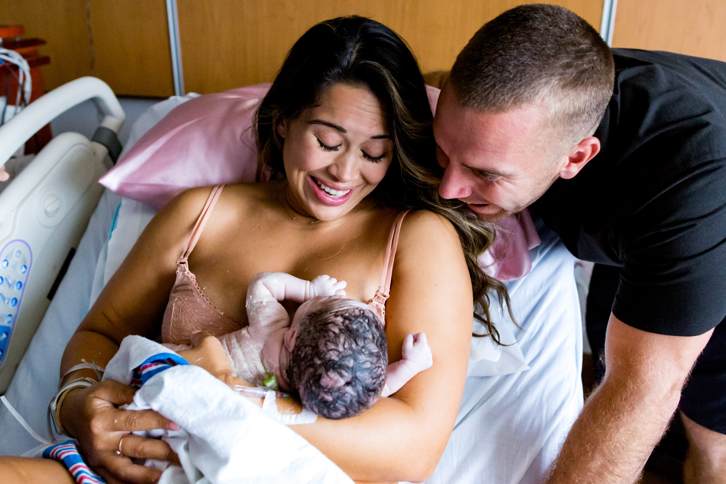 new parents smiling at their newborn baby girl
