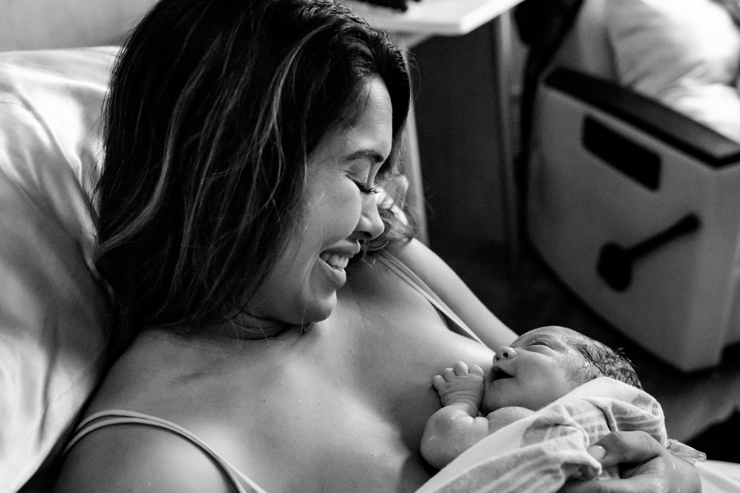 new mom smiling at her baby girl just after birth
