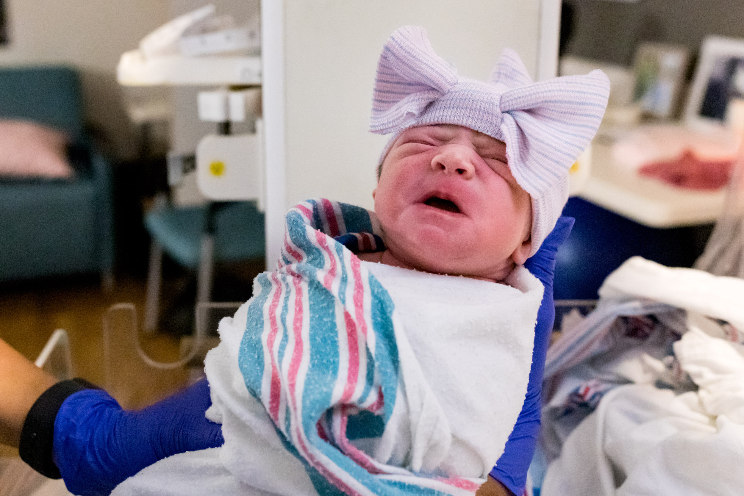 newborn baby girl with bow hat on