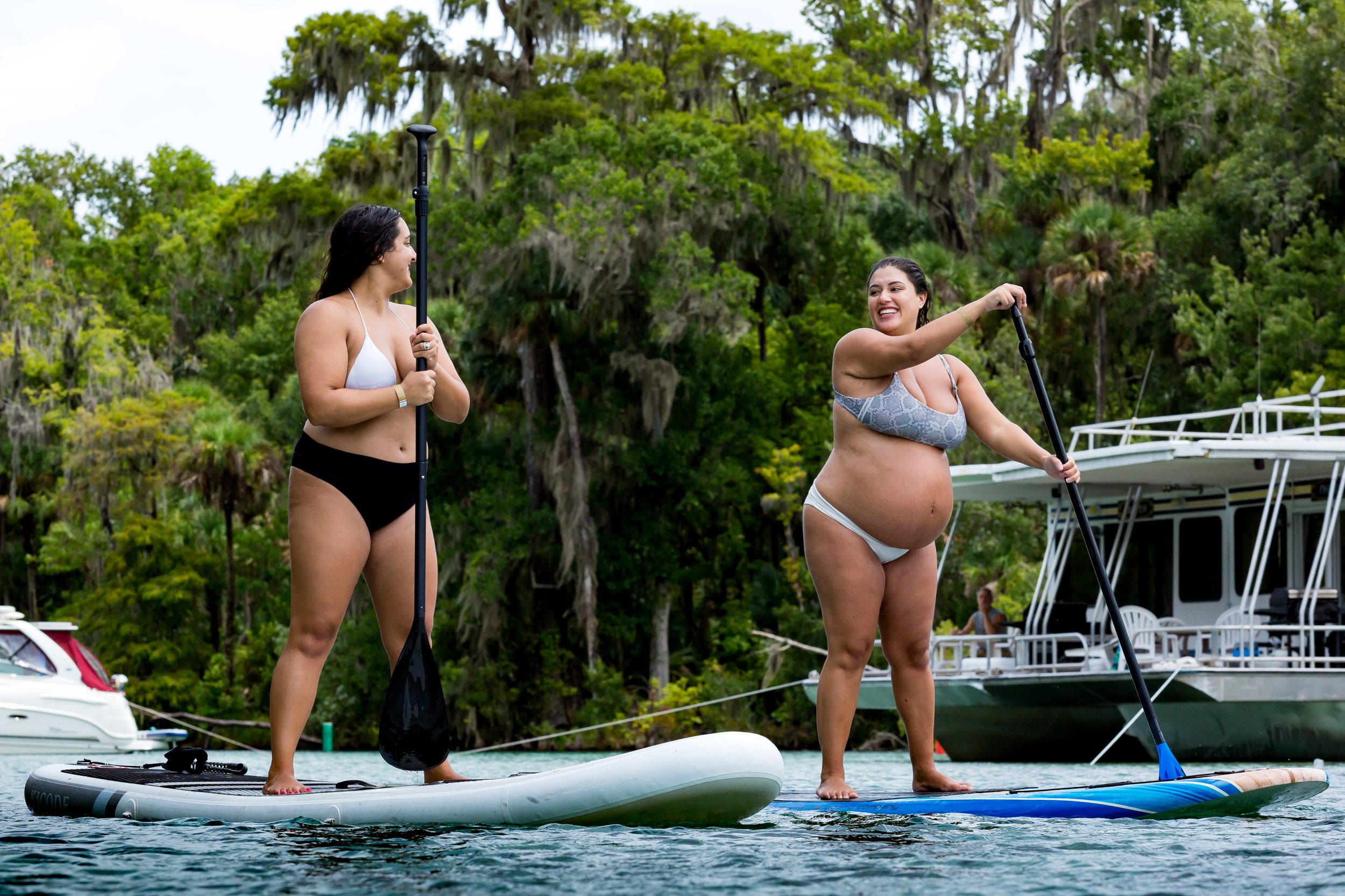 pregnant mom paddleboarding with sister