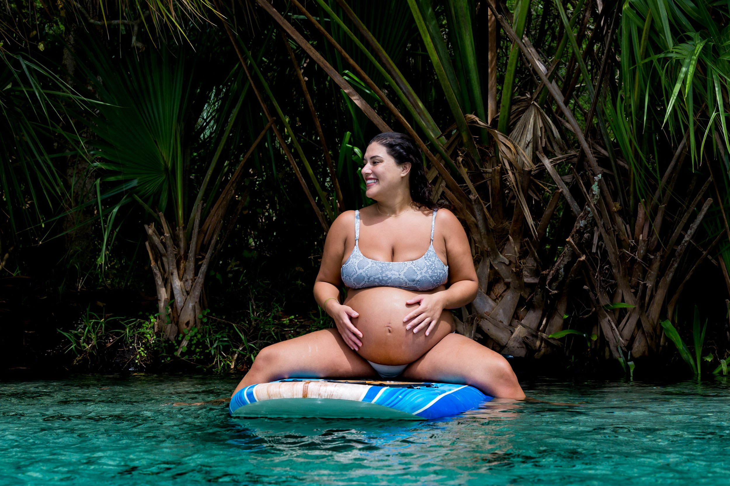 pregnant mom on a paddleboard smiling