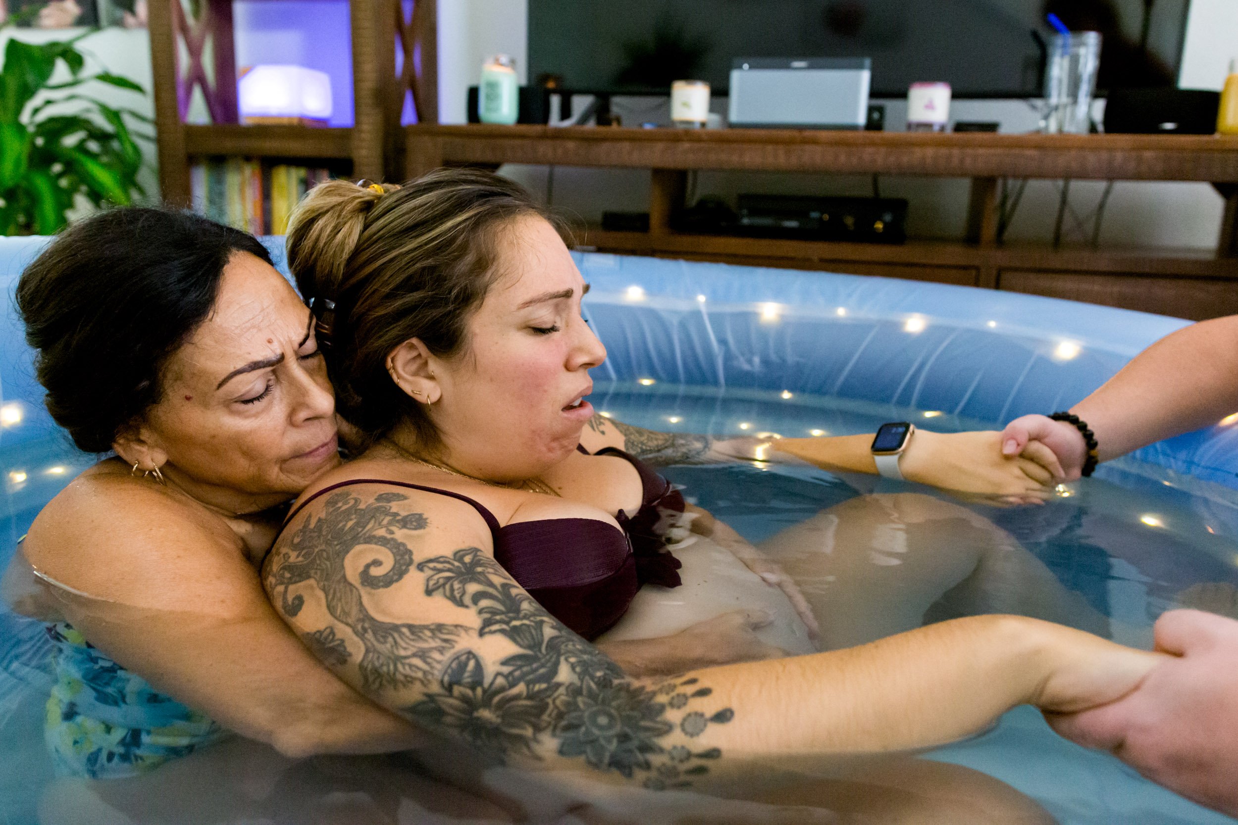jacksonville home birth mom in birth pool with her mom behind her as her doula